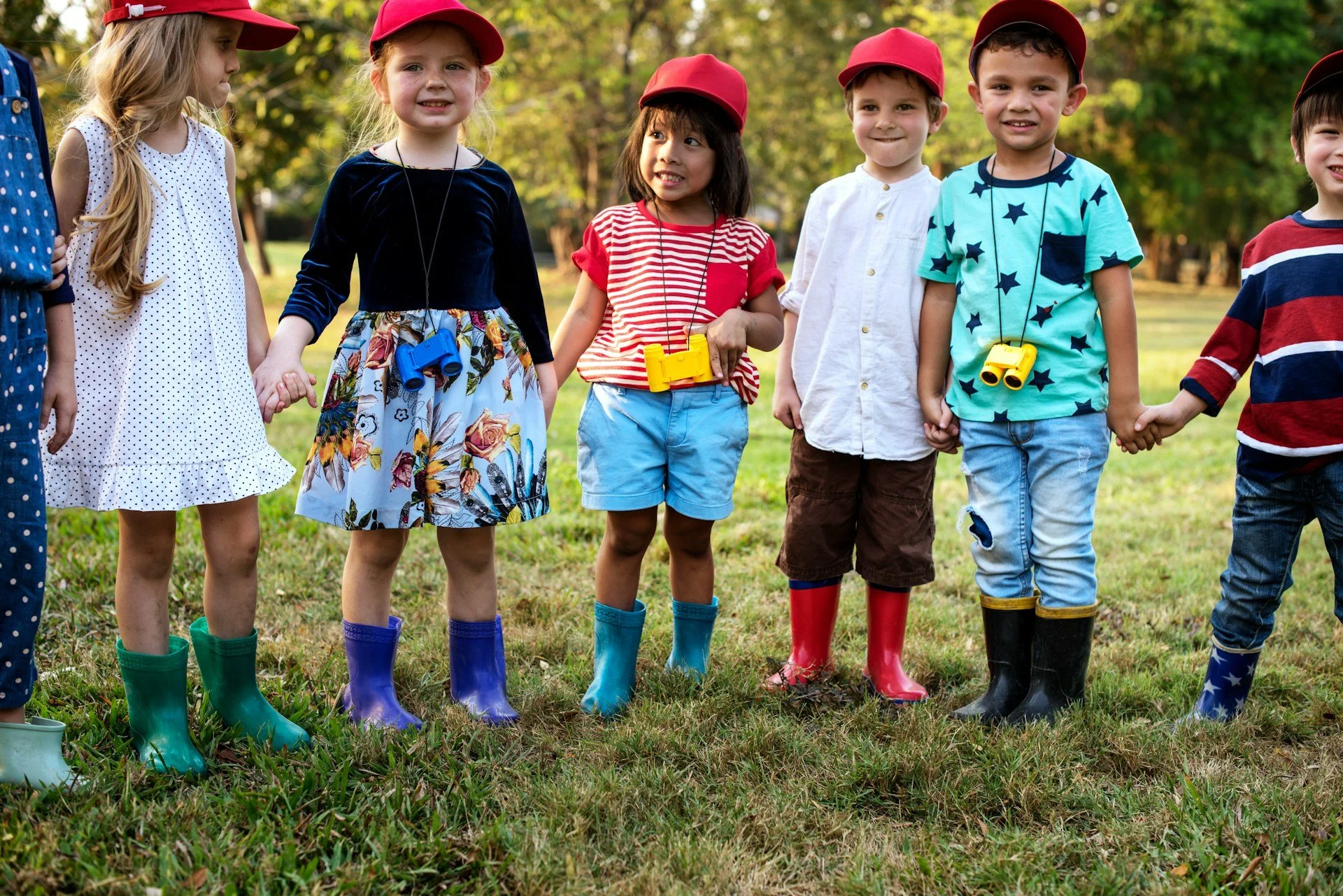Little kids in red hats look at the camera