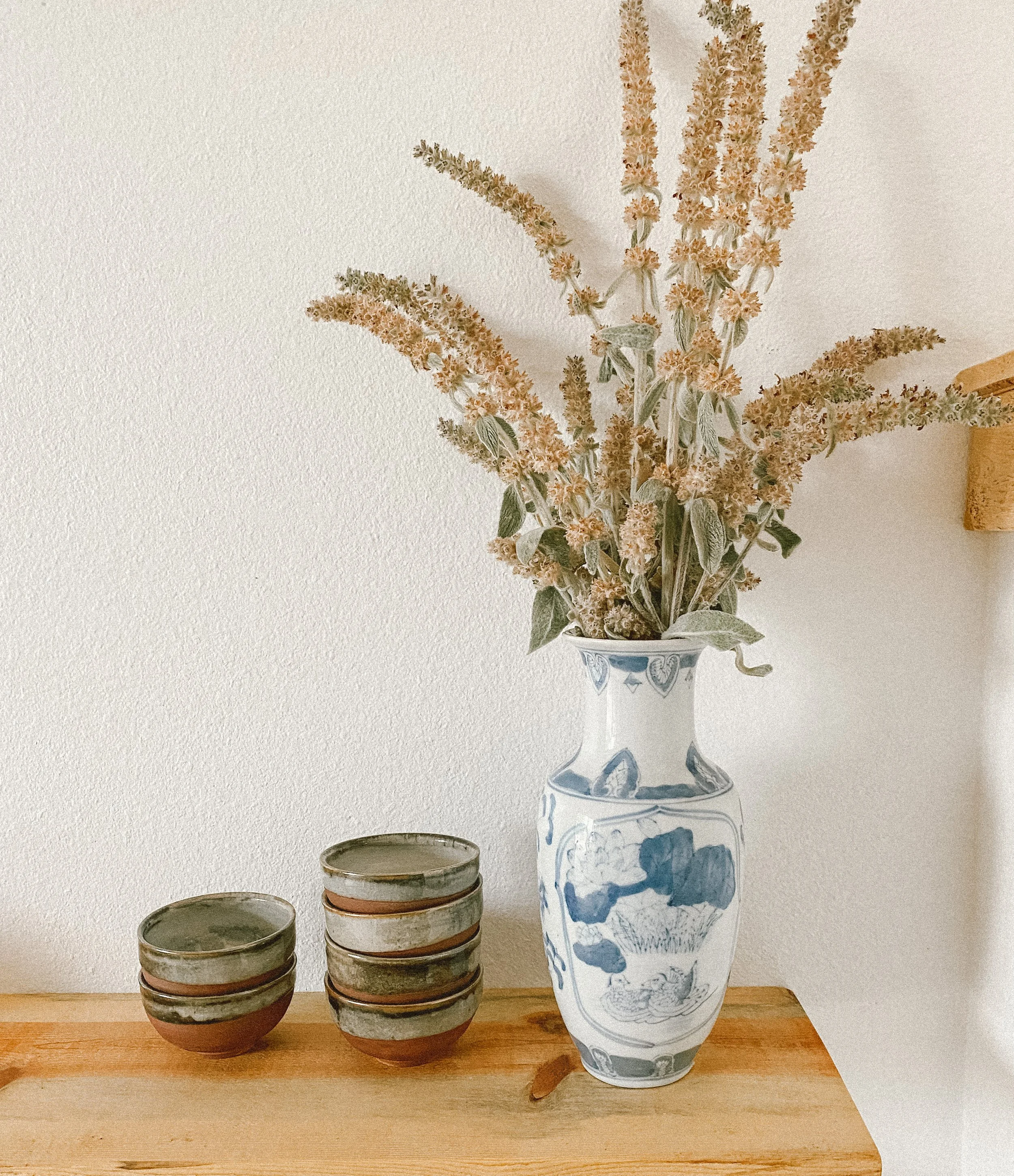 Vase With dried flowers and stacks of tea bowls