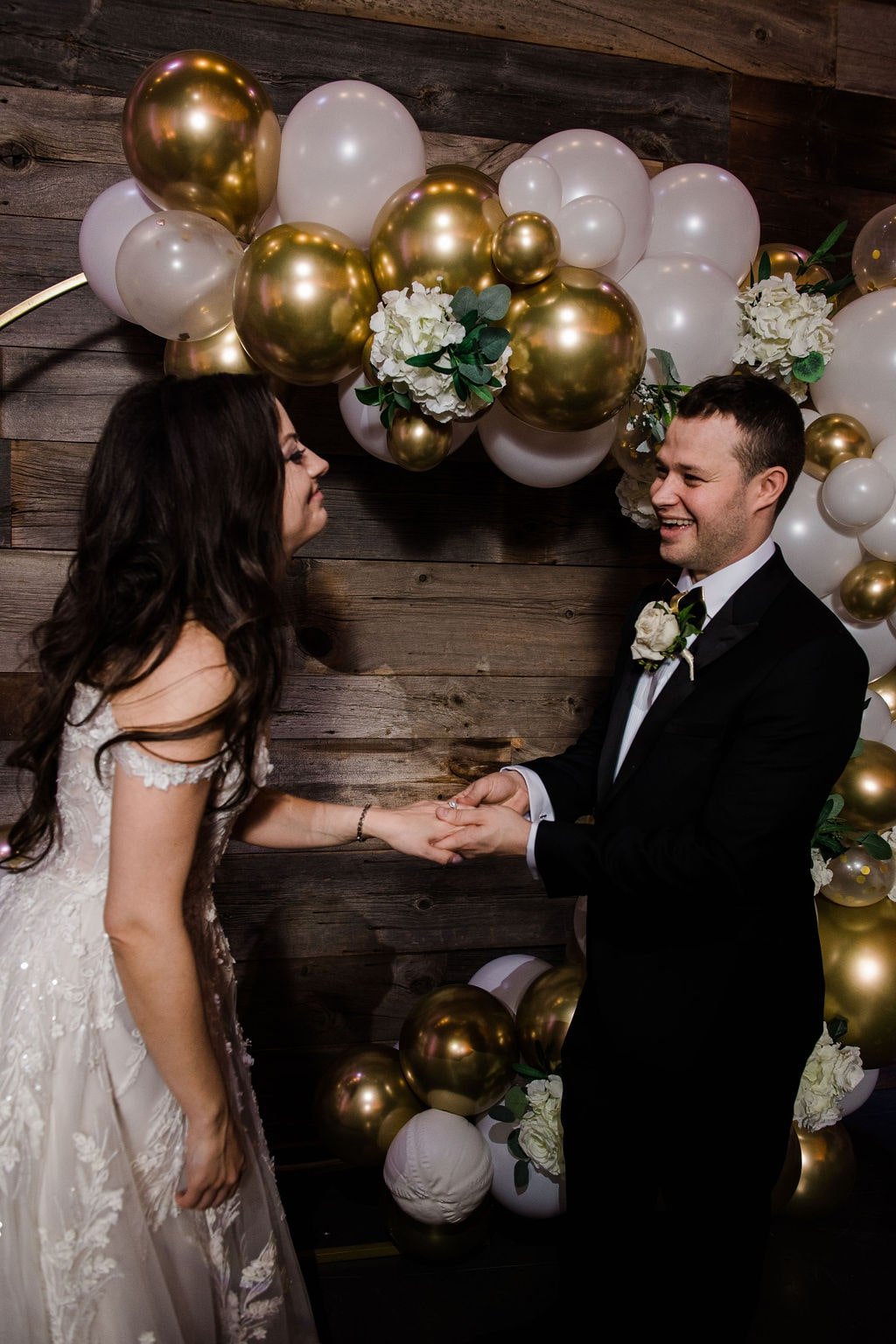 Wedding ceremony with gold and white balloon wedding arch
