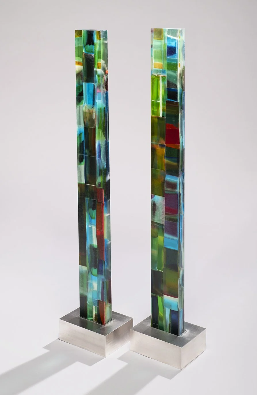 Spire 12 (43 3/4”H x 4 1/2” W x 1 3/4”D) (L) Spire 11 (44”H x 4 1/2” W x 1 3/4”D) (R) both set in a brushed stainless steel base (3”H x 8 3/8"W x 6 1/2”D)
