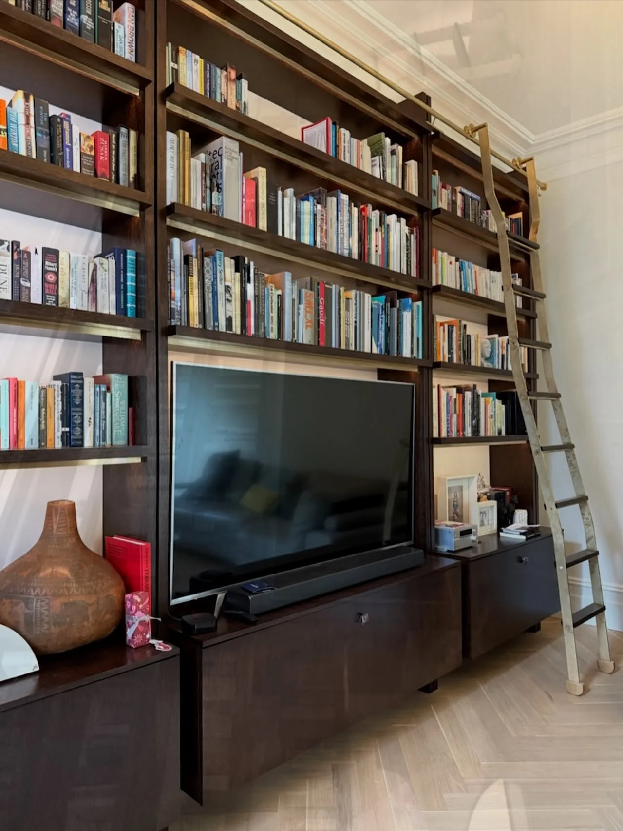 Timber veneer bookcase in a dark walnut stain with custom brass ladder. 

#timberveneer #customjoinery #bookcase