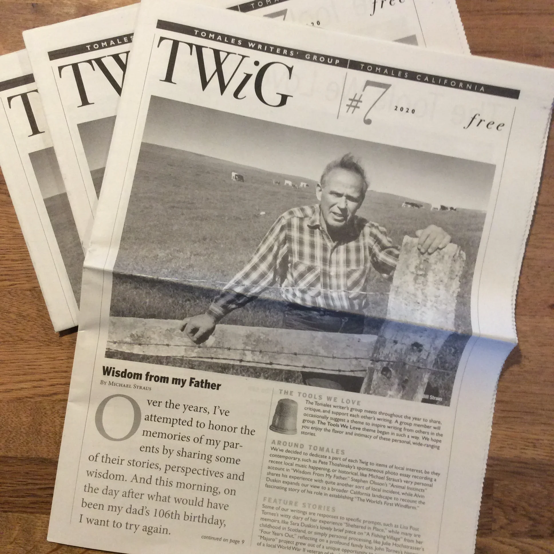 Copies of TWiG newspaper with the cover story “Wisdom from my Father” and a photo of a man at a fence