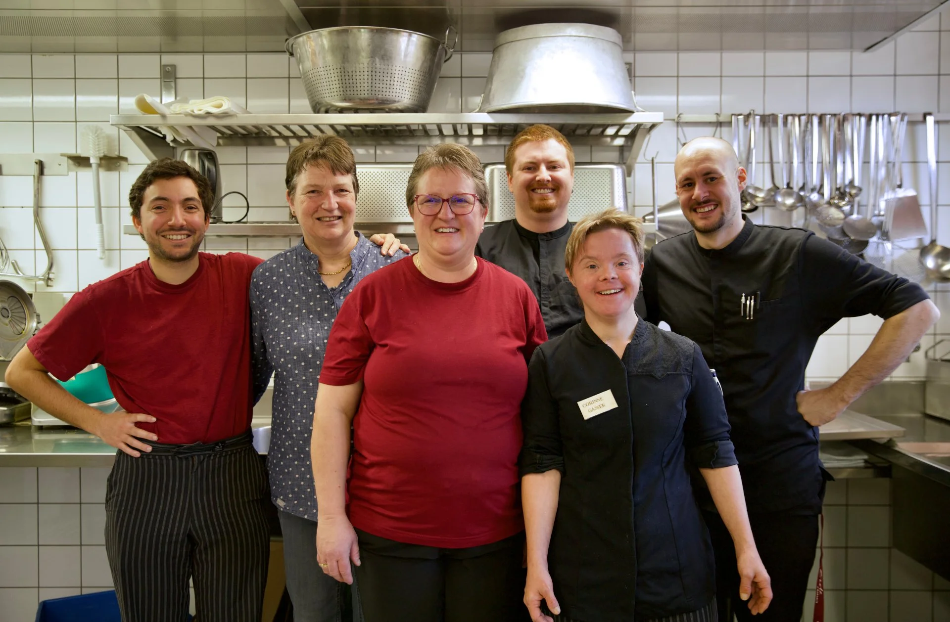 Unser Küchenteam steht in der Küche und lächelt.