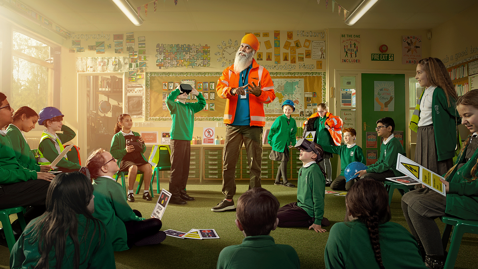 Manny, one of Network Rail's Community Safety Managers, stands in a classroom of primary-school aged children, who are actively engaged in a discussion about rail safety