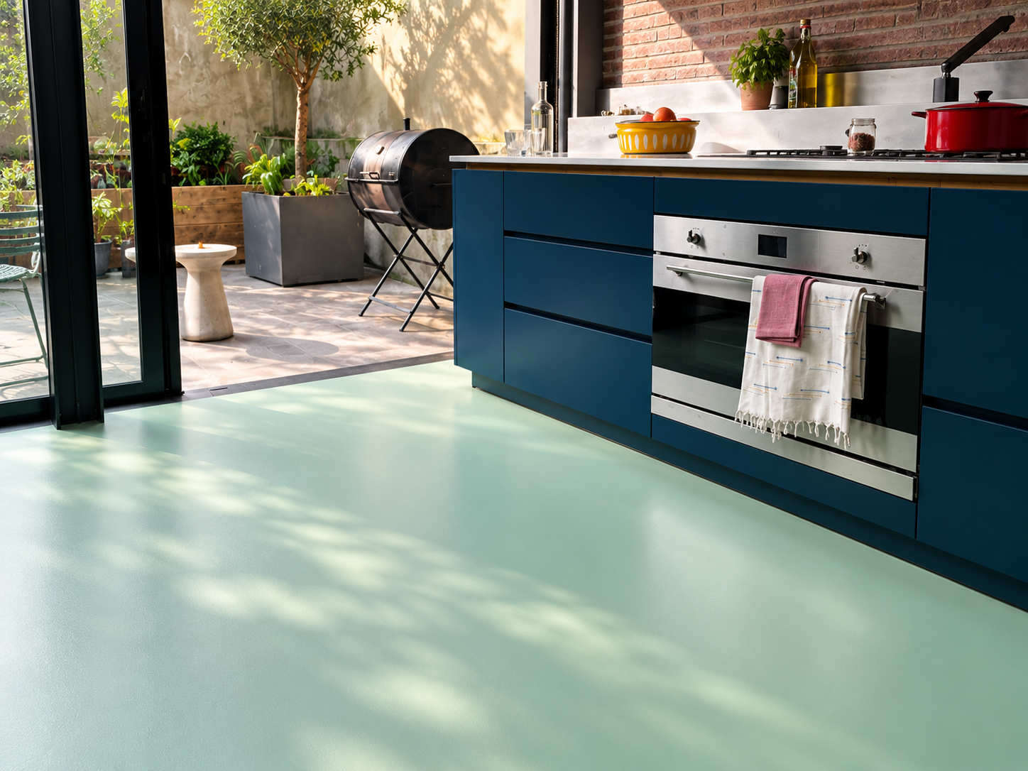 Modern kitchen with professionally installed vinyl flooring by Floor London featuring blue cabinetry and patio doors