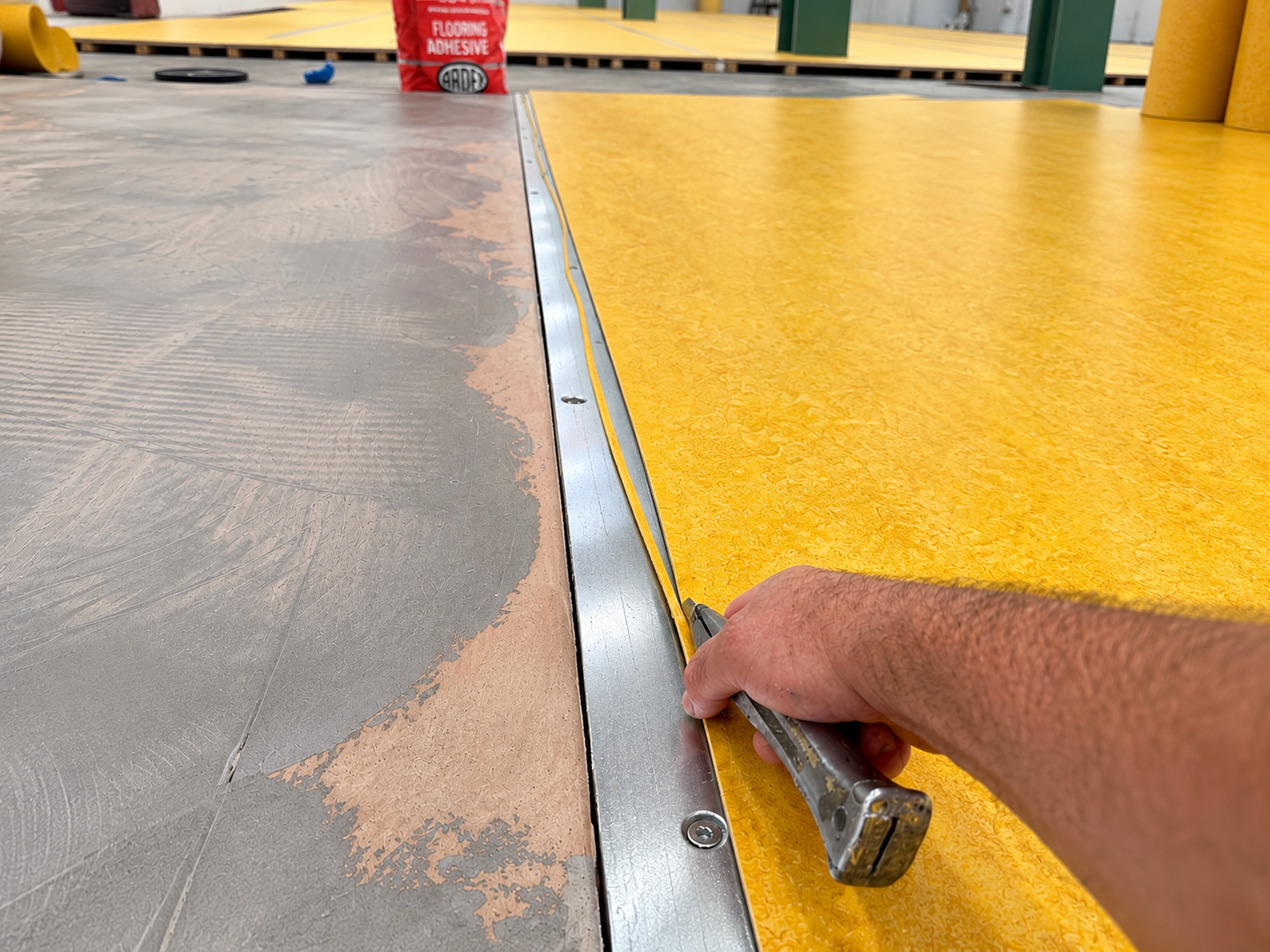 Professional flooring installation by Floor London, cutting and fitting yellow Marmoleum flooring on site