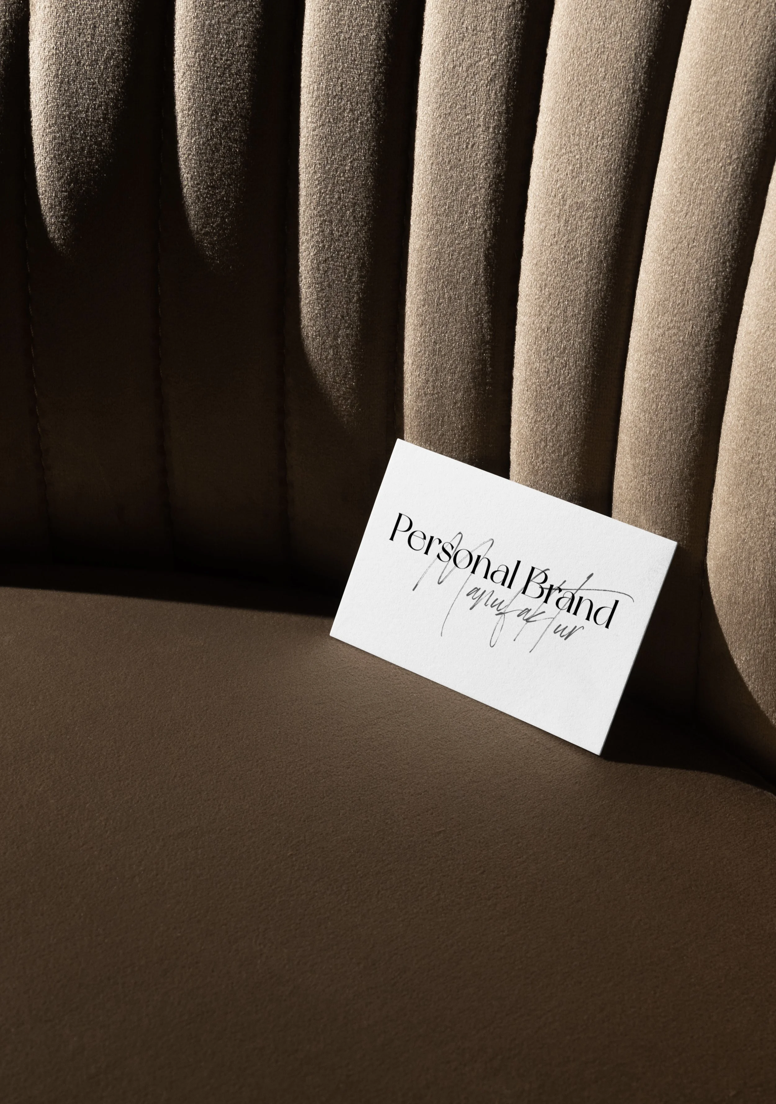Visitenkarte mit der Aufschrift 'Personal Brand' auf einem braunen, gepolsterten Sitz.