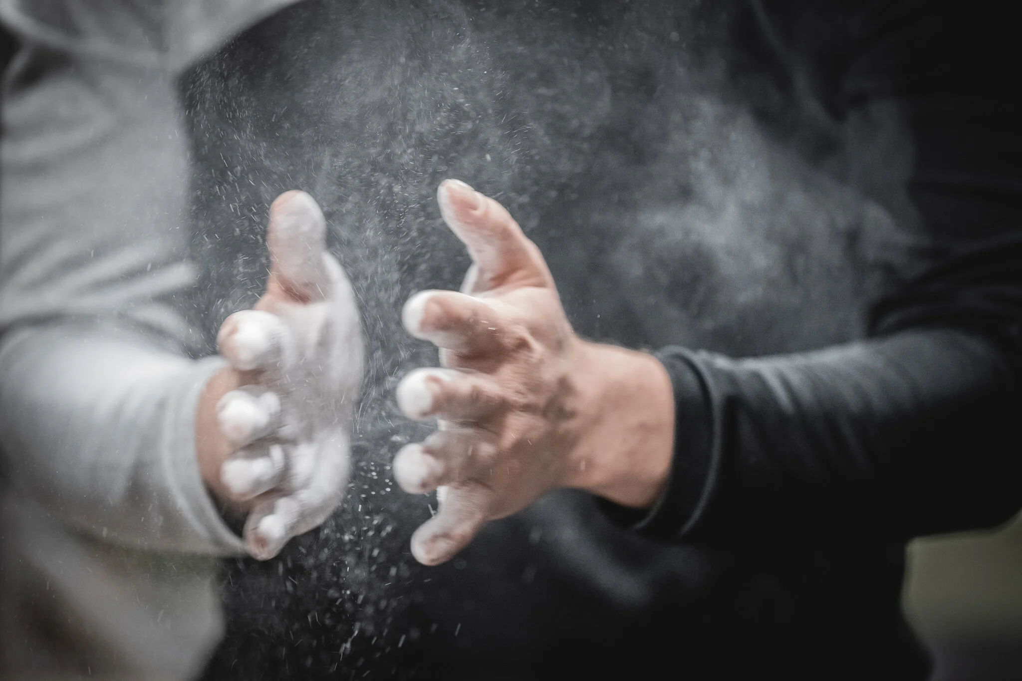 Zwei Personen beim gemeinsam Mehl streuen.