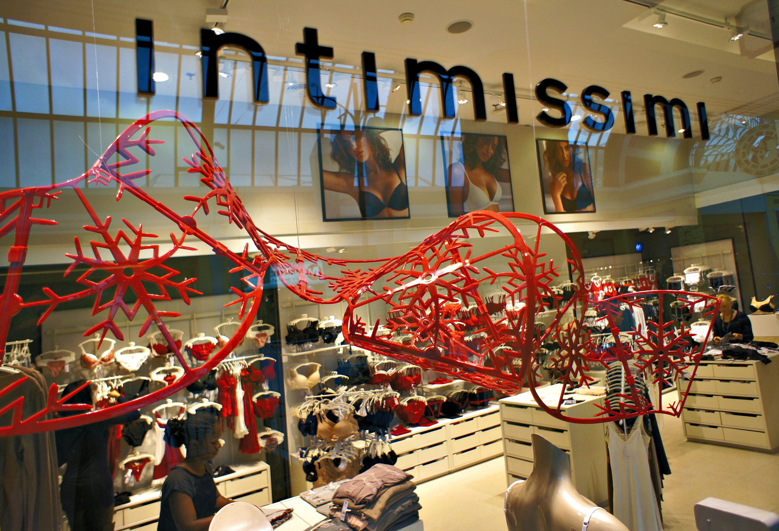 Intimissimi store interior with lingerie display and red holiday decorations.