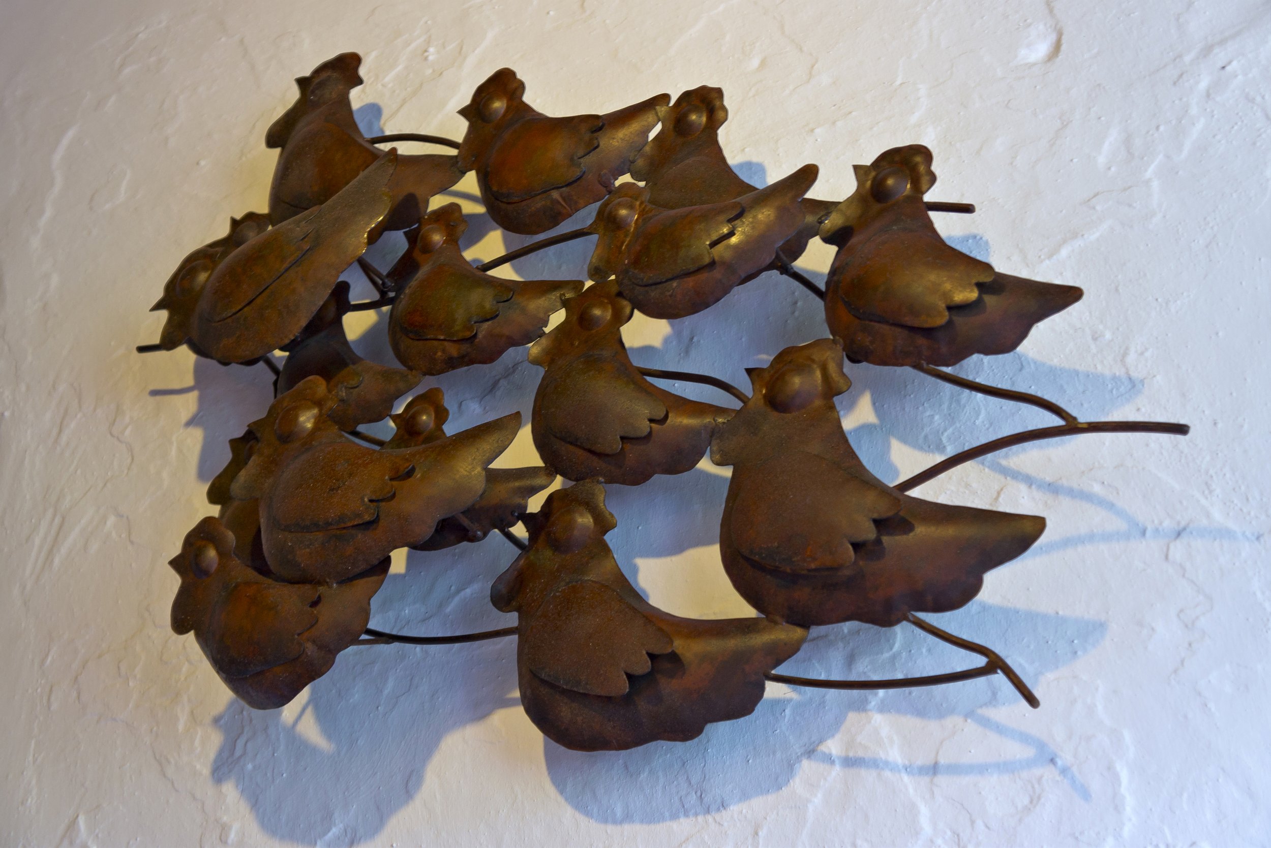 Wall art with metal birds clustered together