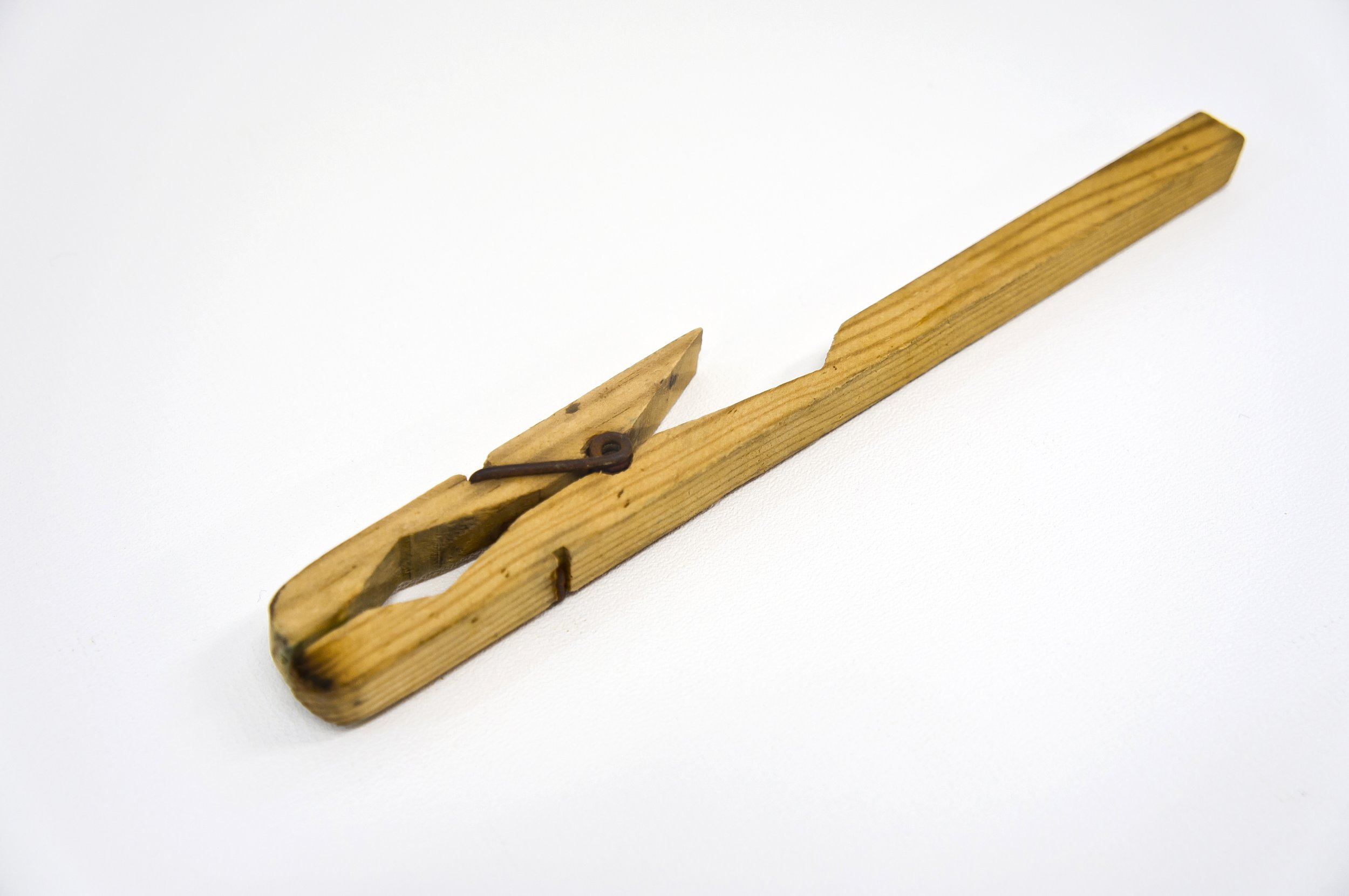 A wooden spaghetti measuring tool on a white background.