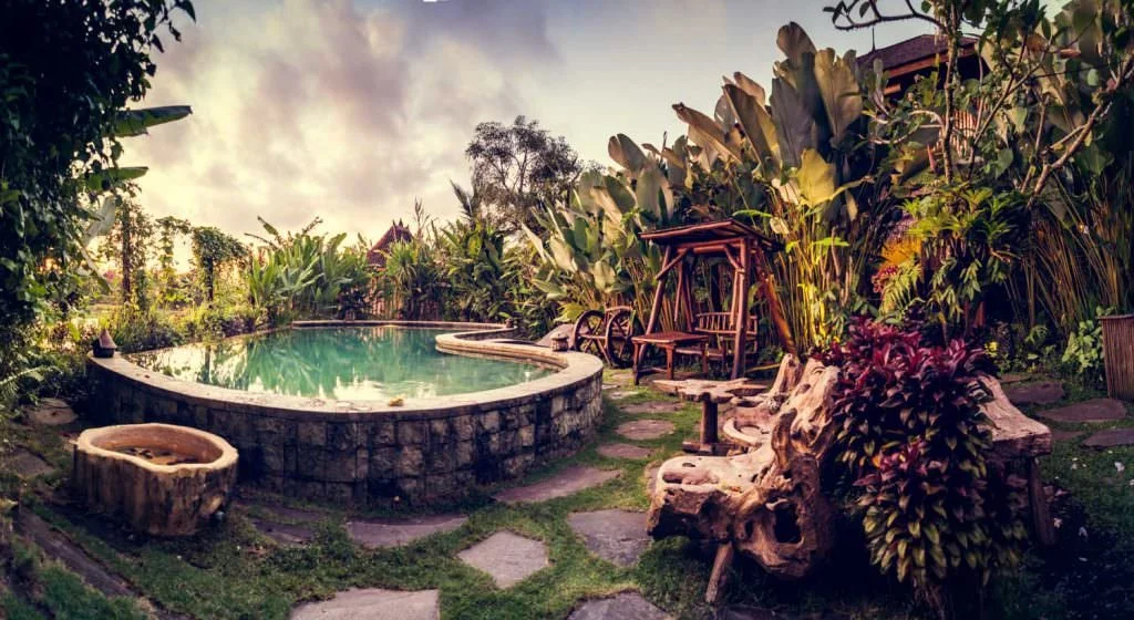 Piscine d'eau salée à débordement et espaces de ressourcement spirituel au Dragonfly Village à Ubud, Bali.