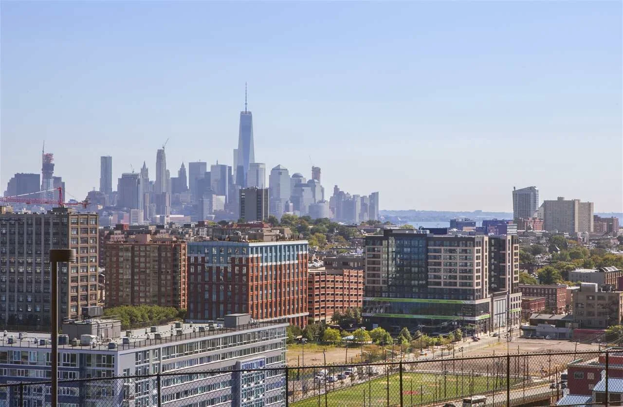 Cityscape of Jersey City neighborhood housing markets showing the architectural transition from the Heights palisades to Downtown high-rise properties.