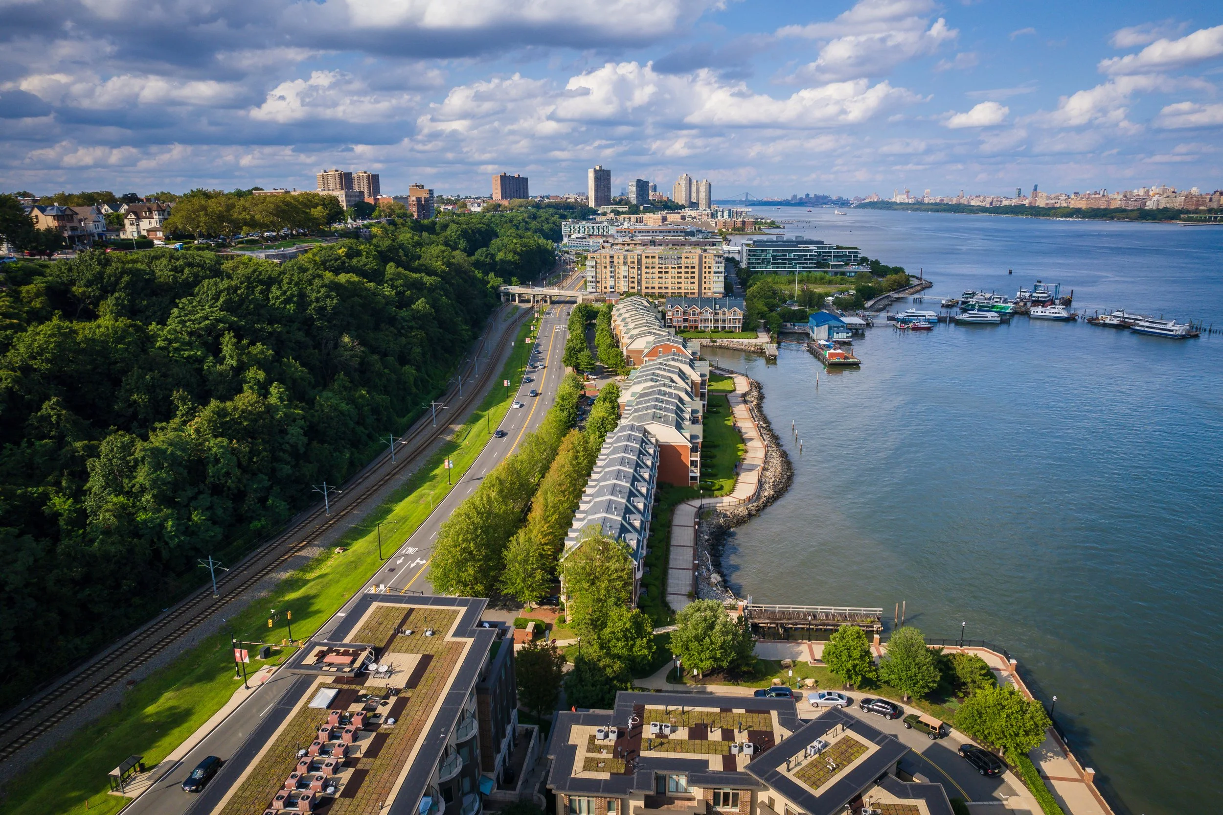 Aerial view of the Weehawken waterfront and transit lines along the Hudson River, representing the local Hudson County real estate market (HCMLS / RMLSNJ).
