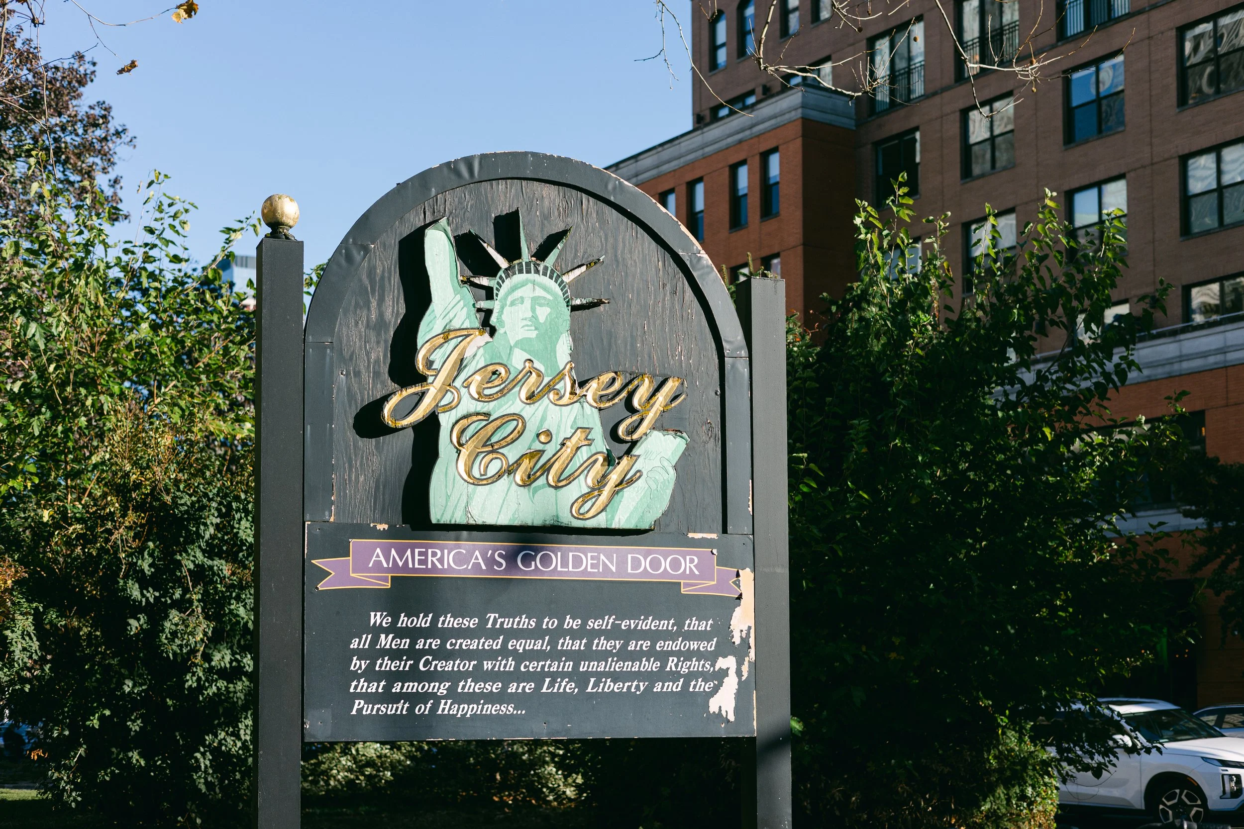 Jersey City Americas Golden Door sign featuring the Statue of Liberty and Declaration of Independence quote