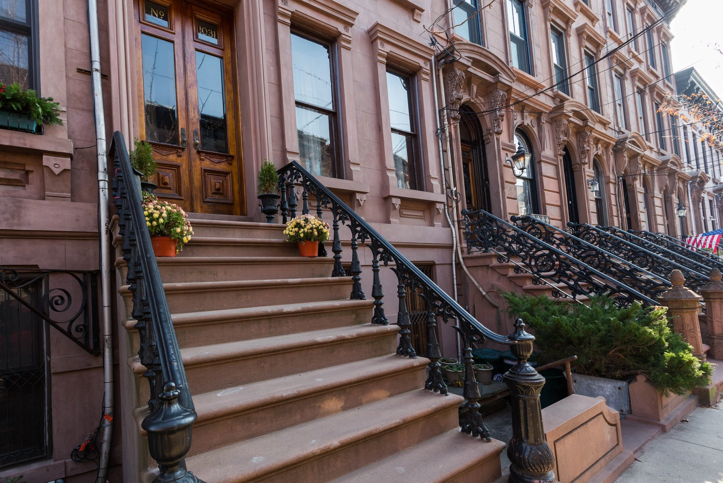 Springtime residential street in Hoboken NJ showing townhomes and green trees