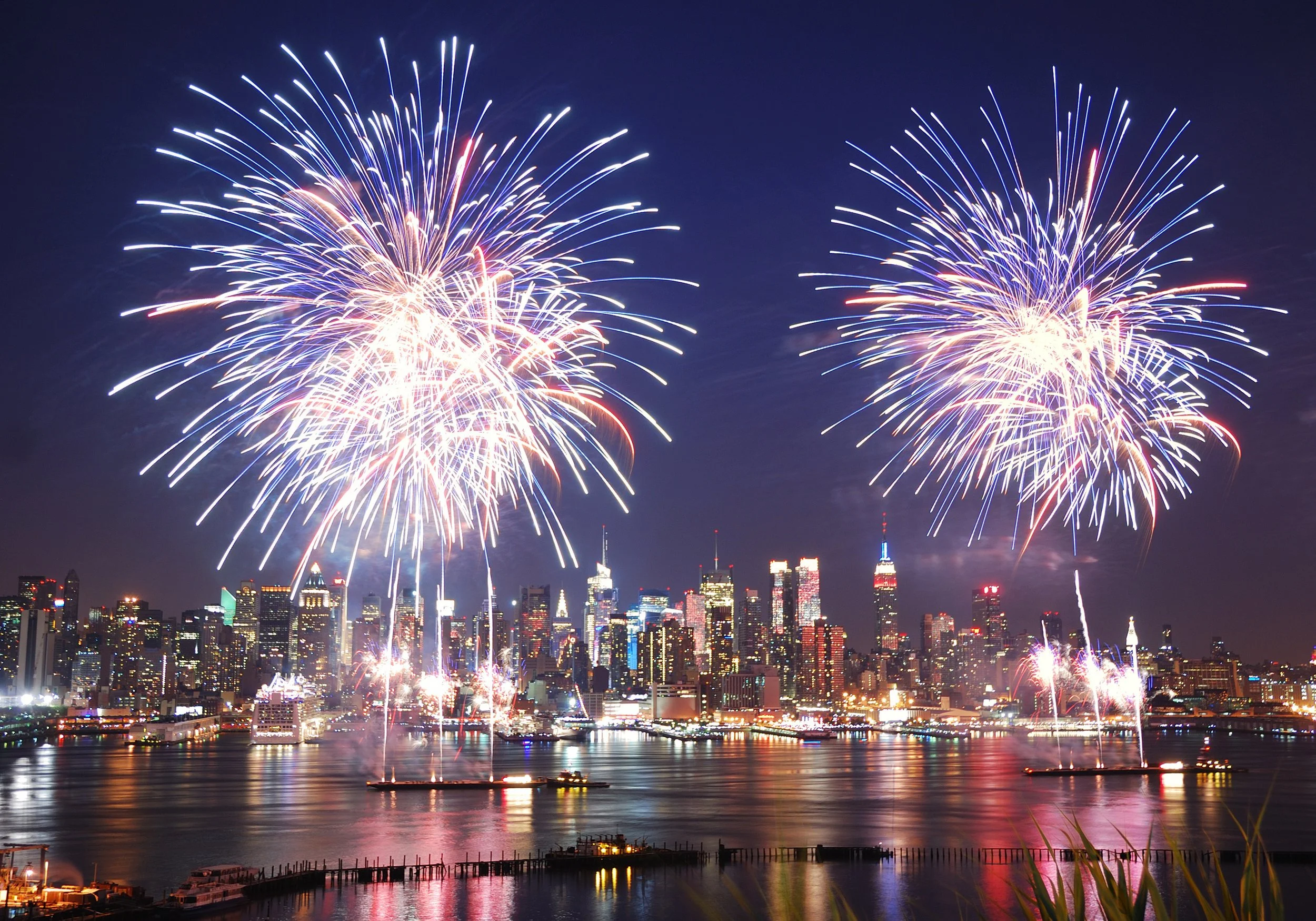 Fireworks illuminate the Hudson River and Manhattan skyline during Independence Day celebrations near Hoboken, New Jersey.