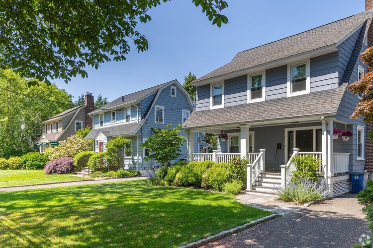 Blue-gray colonial home with a front porch and garden on a tree-lined street in Maplewood, New Jersey