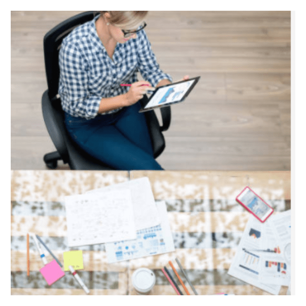 Woman in jeans and a plaid shirt working on her phone.