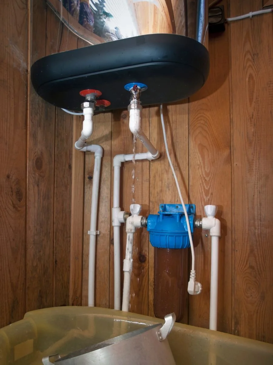 close up of a water heater heater leaking from bottom