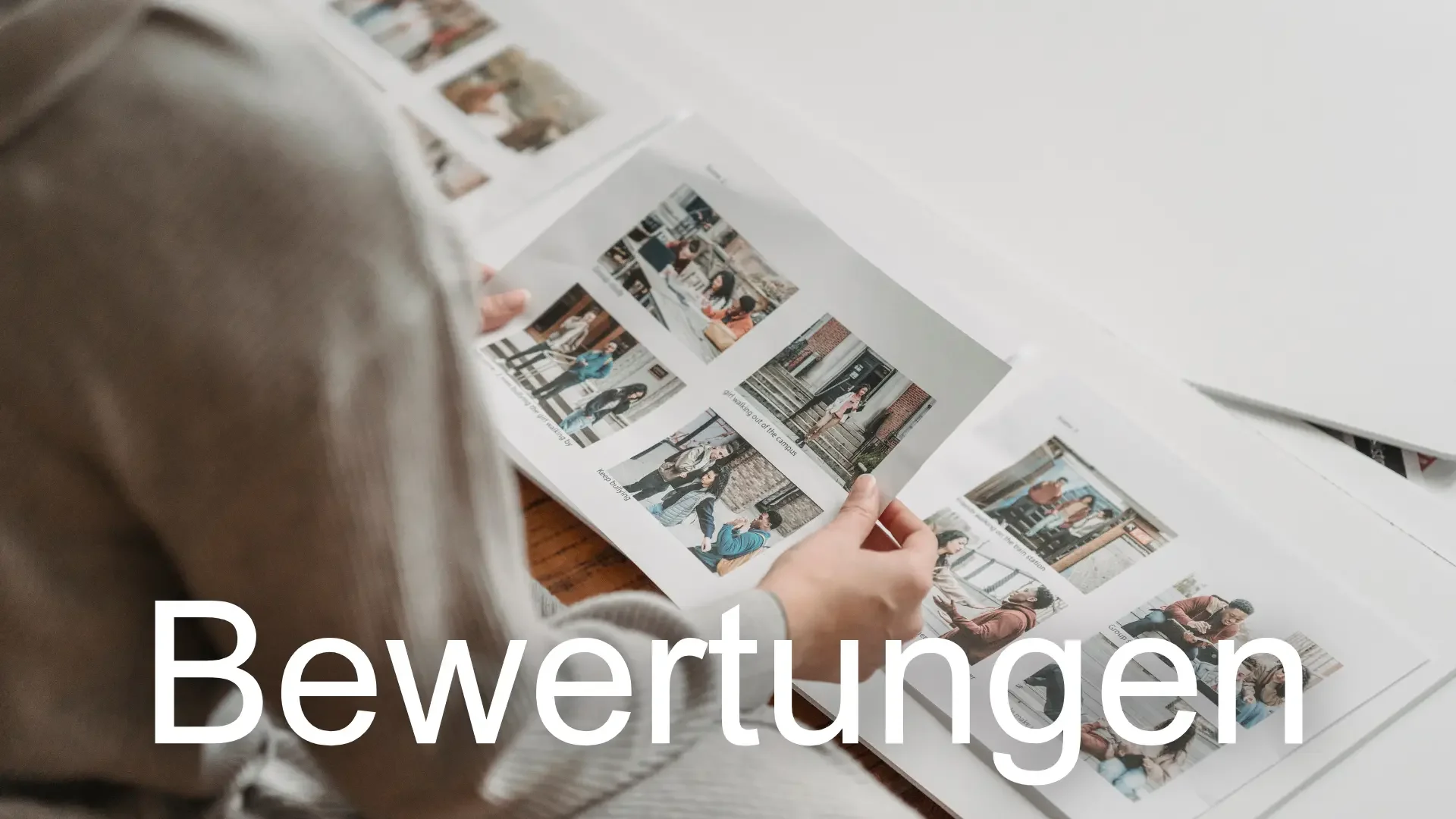 Person blättert in einem Fotobuch mit dem Text 'Bewertungen' im Vordergrund.