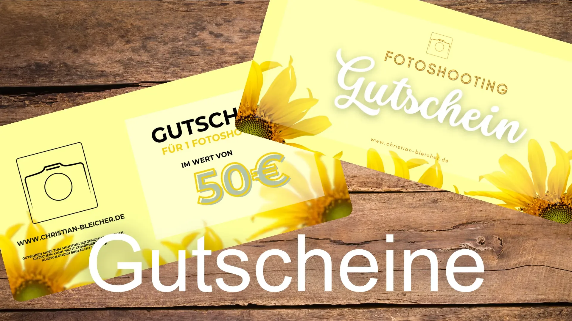 Zwei gelbe Gutscheine für ein Fotoshooting im Wert von 50 Euro mit Sonnenblumenmotiv auf einem Holztisch.