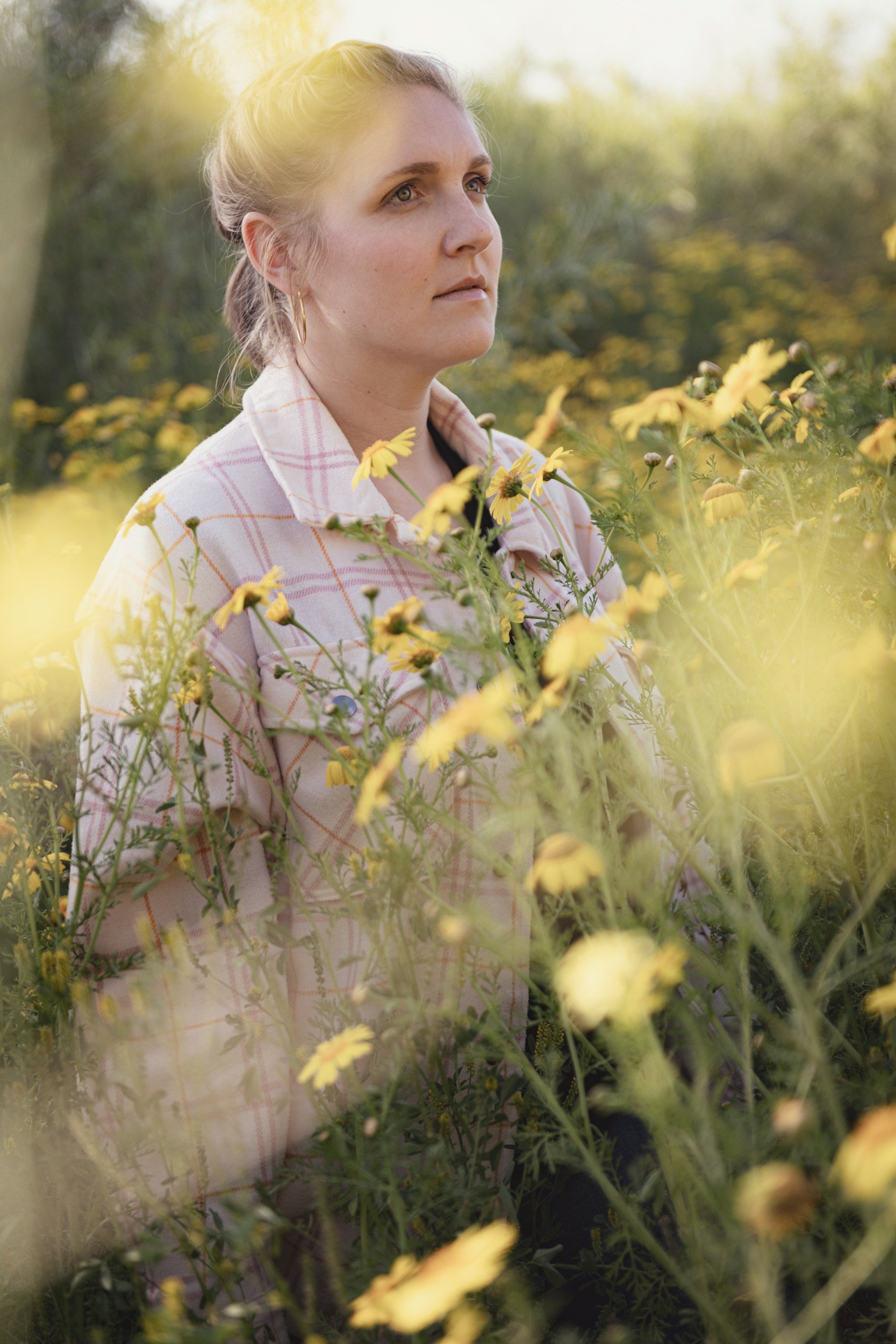 A woman standing in a natural setting, reflecting on leadership, presence, and perspective