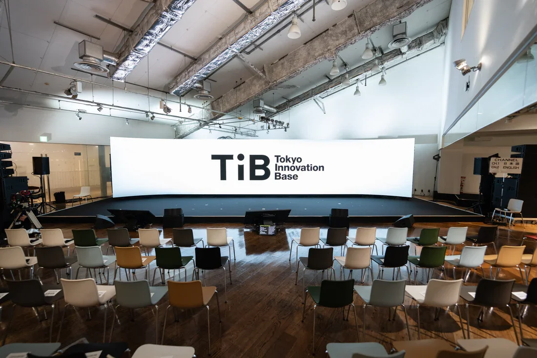 Heather Dobbin speaking at Tokyo Innovation Base (TIB) event in Tokyo, community manager leading a talk with a projected video call behind her