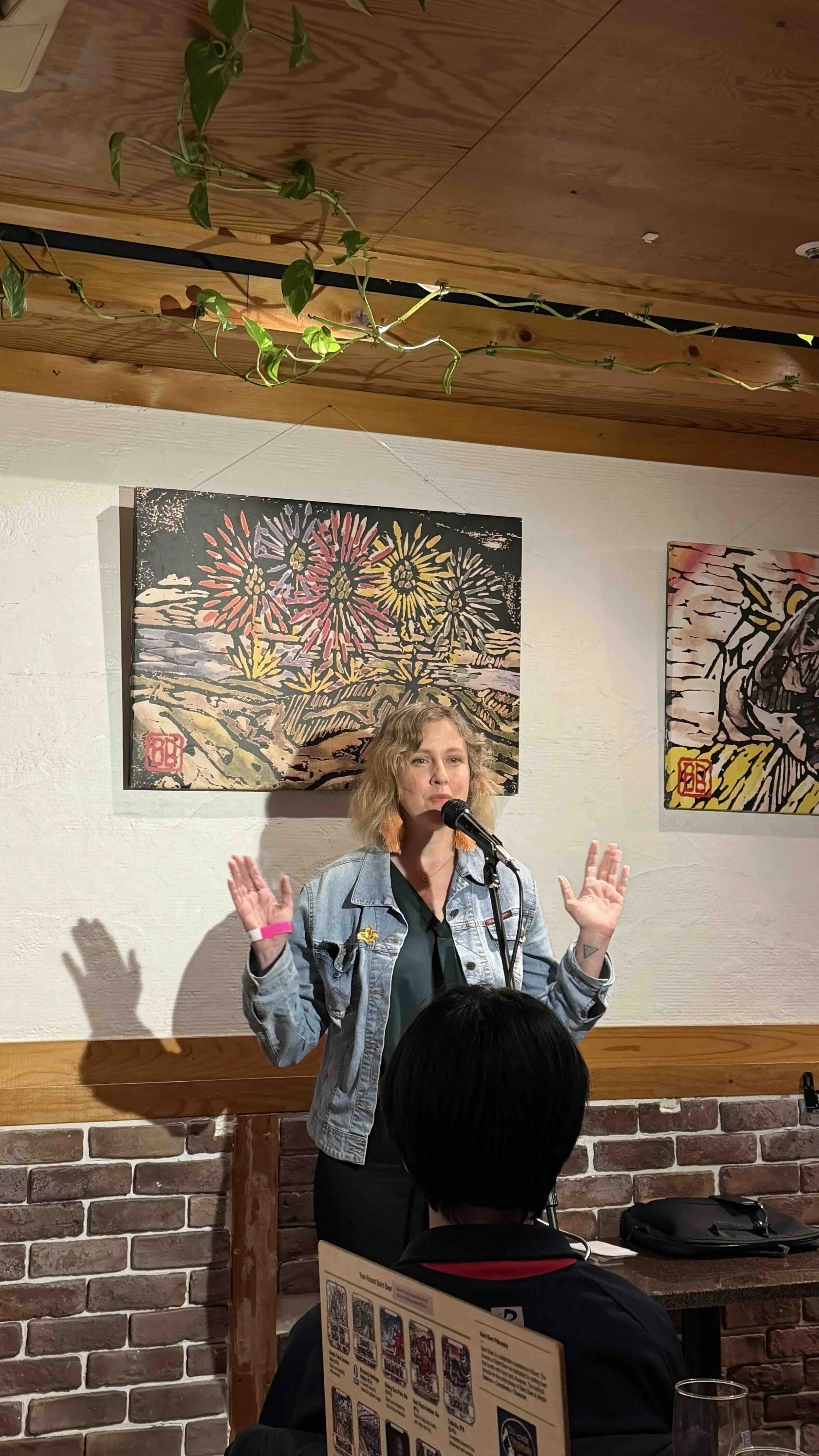 a woman tells a story in front of an audience at a bar