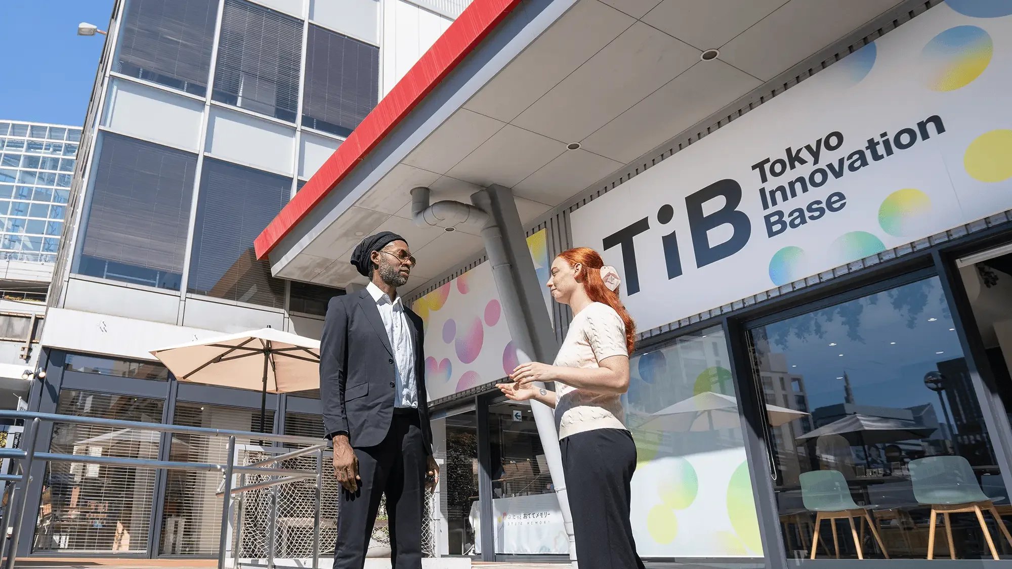 Exterior of Tokyo Innovation Base (TIB) in Tokyo with TiB signage as community members connect outside the venue