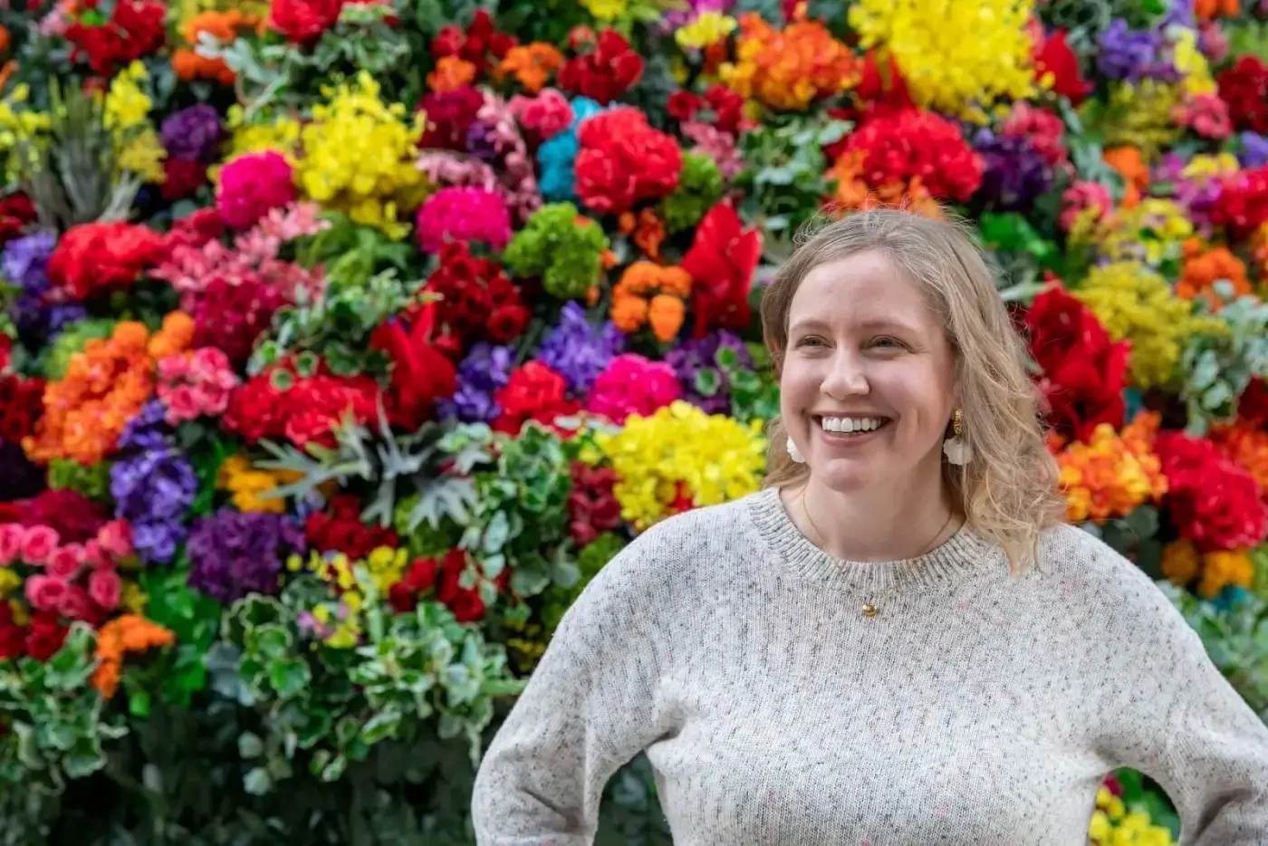 Heather Dobbin smiling outdoors in front of colorful flowers, facilitator of a women-only mindfulness hike and picnic in Zushi, Japan