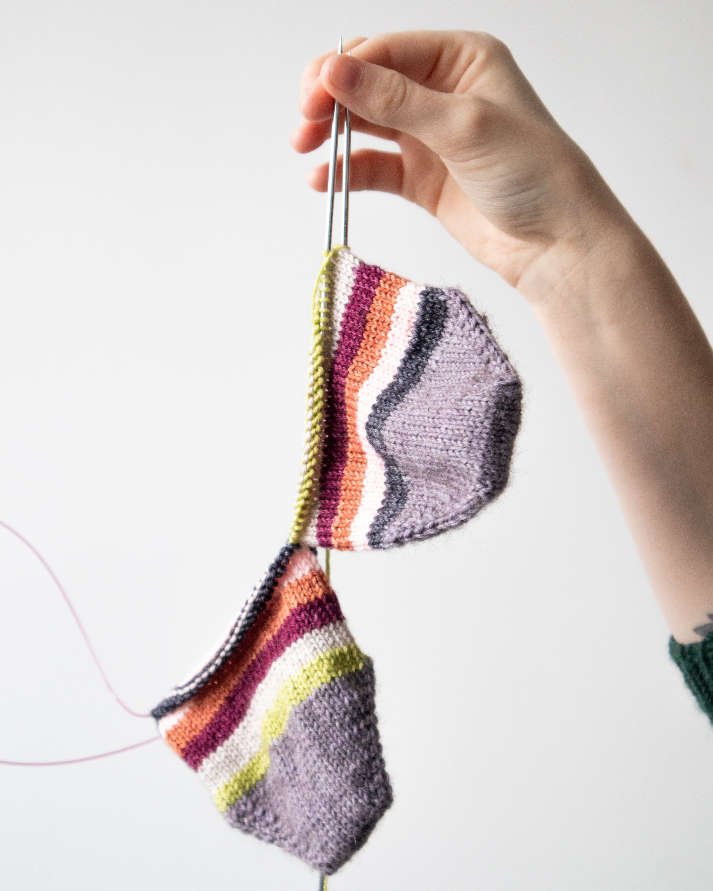 Main tenant deux chaussettes tricotées ensemble en Magic loop sur une aiguille circulaire Hiya hiya Sharp.