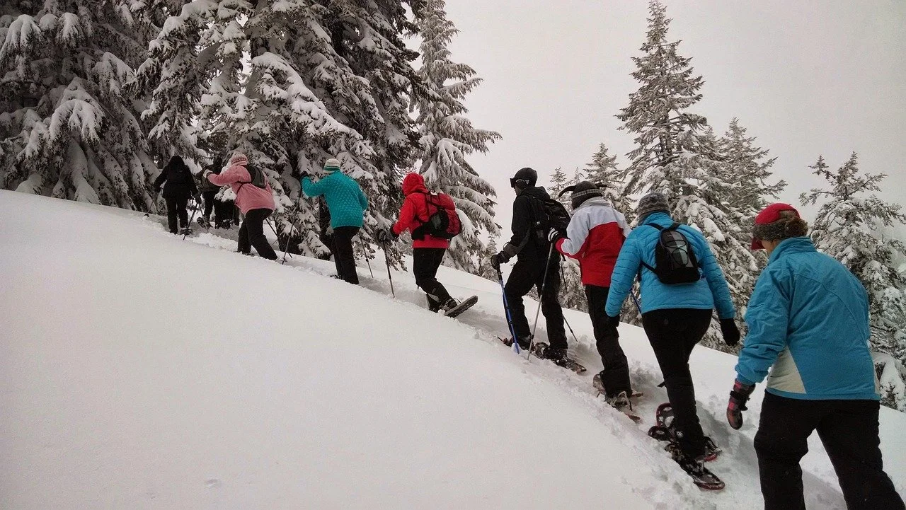 Small group snowshoeing through deep snow in Bymarka