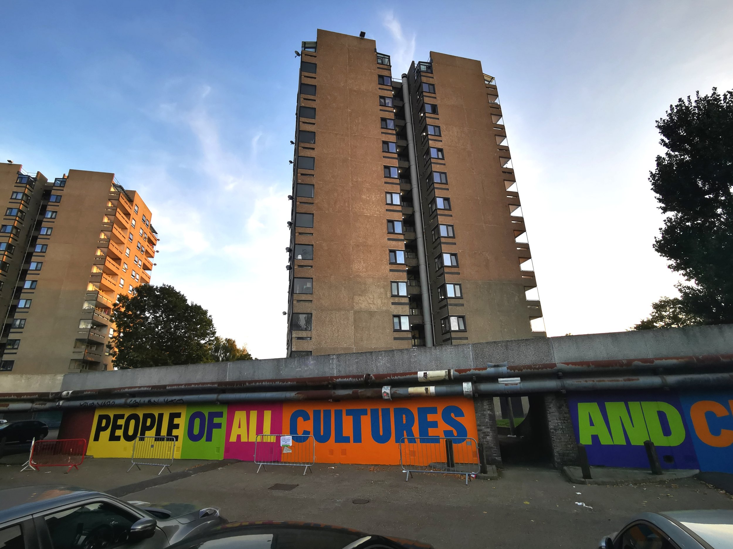  70m long mural commissioned by Peabody for Thamesmead Street Art Trail. The mural reads ‘ People of all cultures and creeds, come together and create the future that Thamesmead needs.’ 