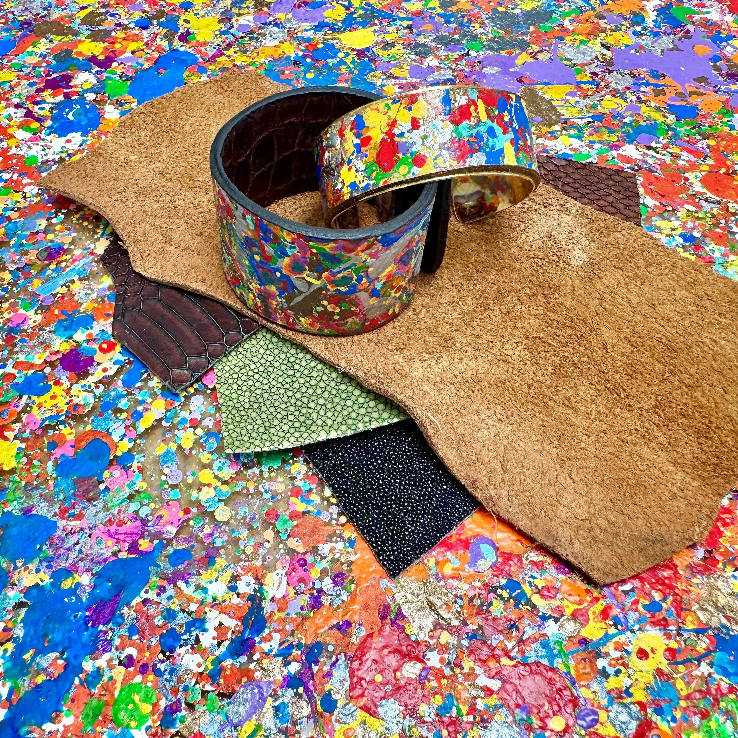 Leather cuffs on splatter painted background