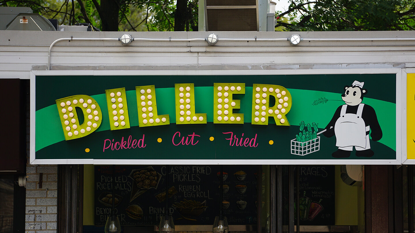  Custom fabricated channel sign reading “Diller” illuminated with yellow bulbs and a retro-styled custom-designed bear mascot painted to the right 