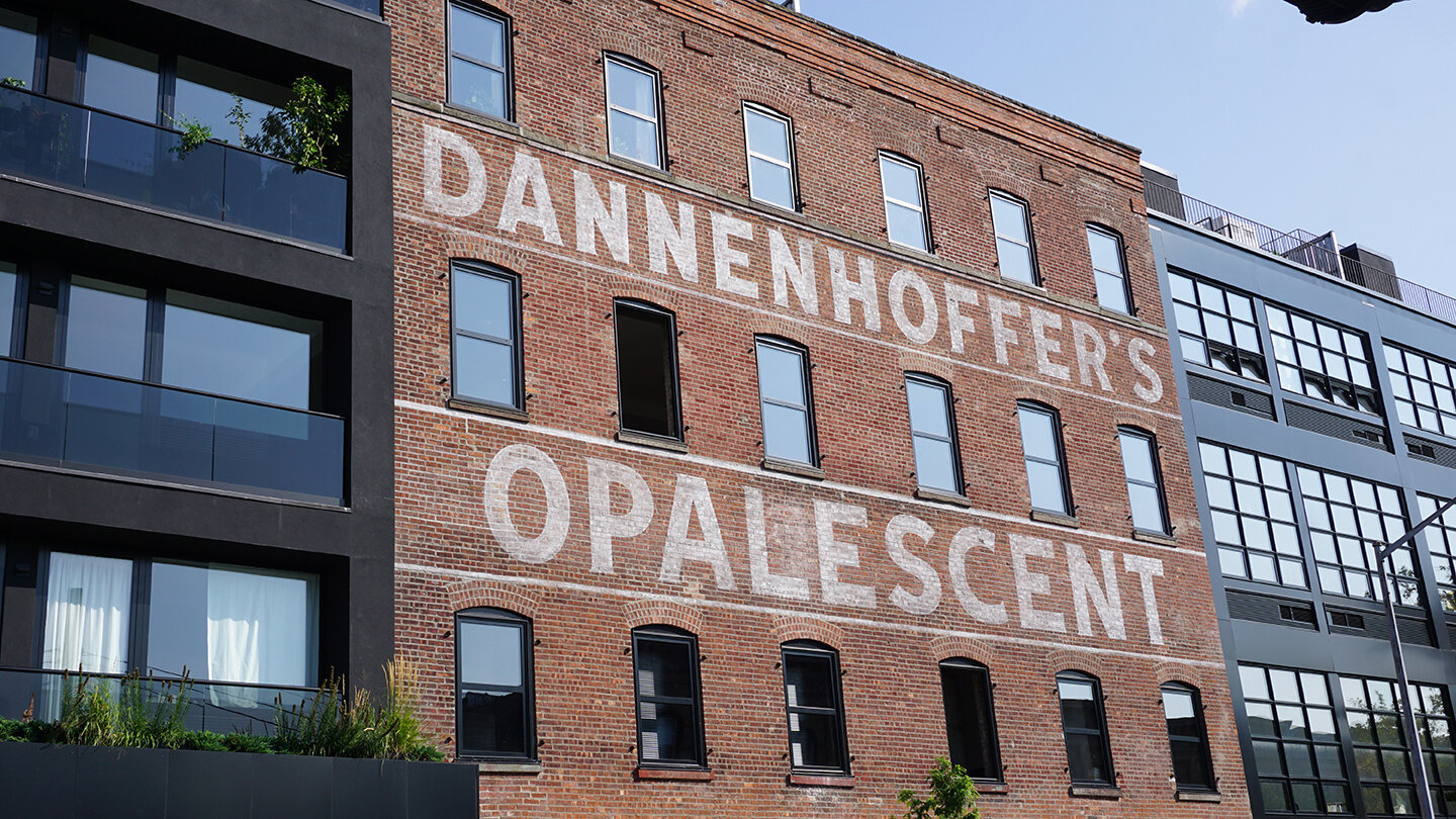  Ghost sign restoration of historic “Dannenhoffer’s Opalescent” sign: white paint with a faded effect on brick 