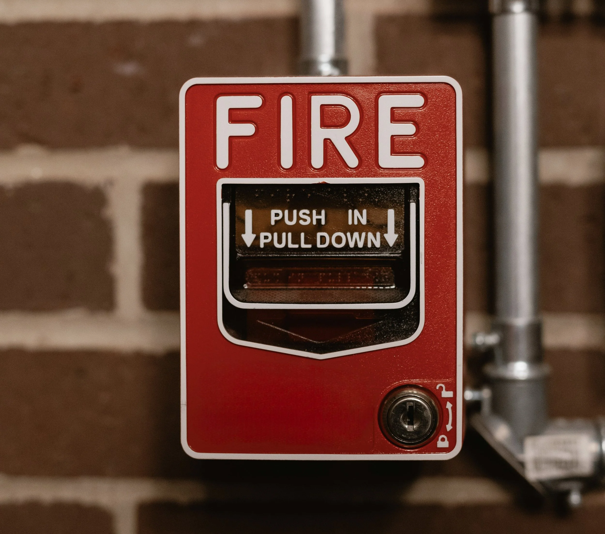 Close-up of a red fire alarm with instructions to push in and pull down.