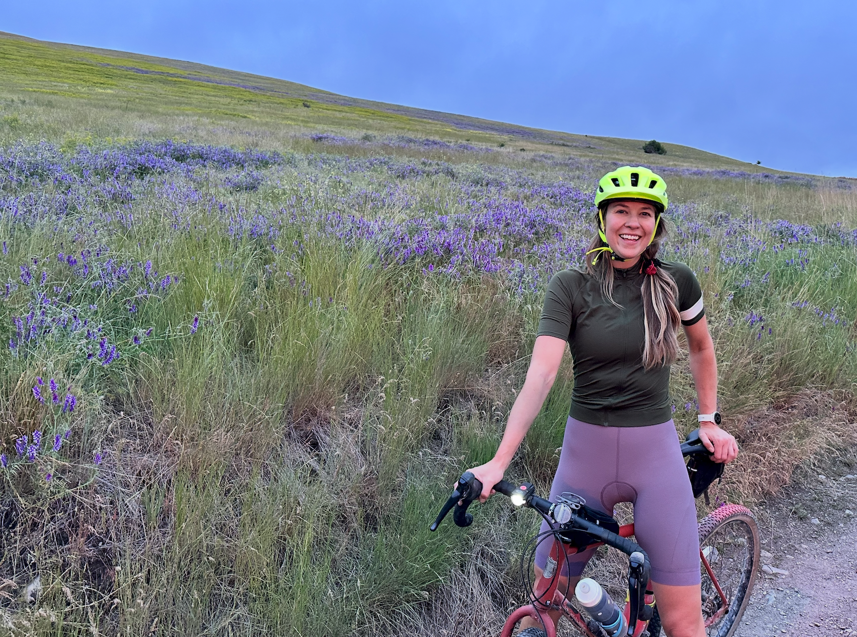Ro Myra with her gravel bicycle among wildflowers in Montana