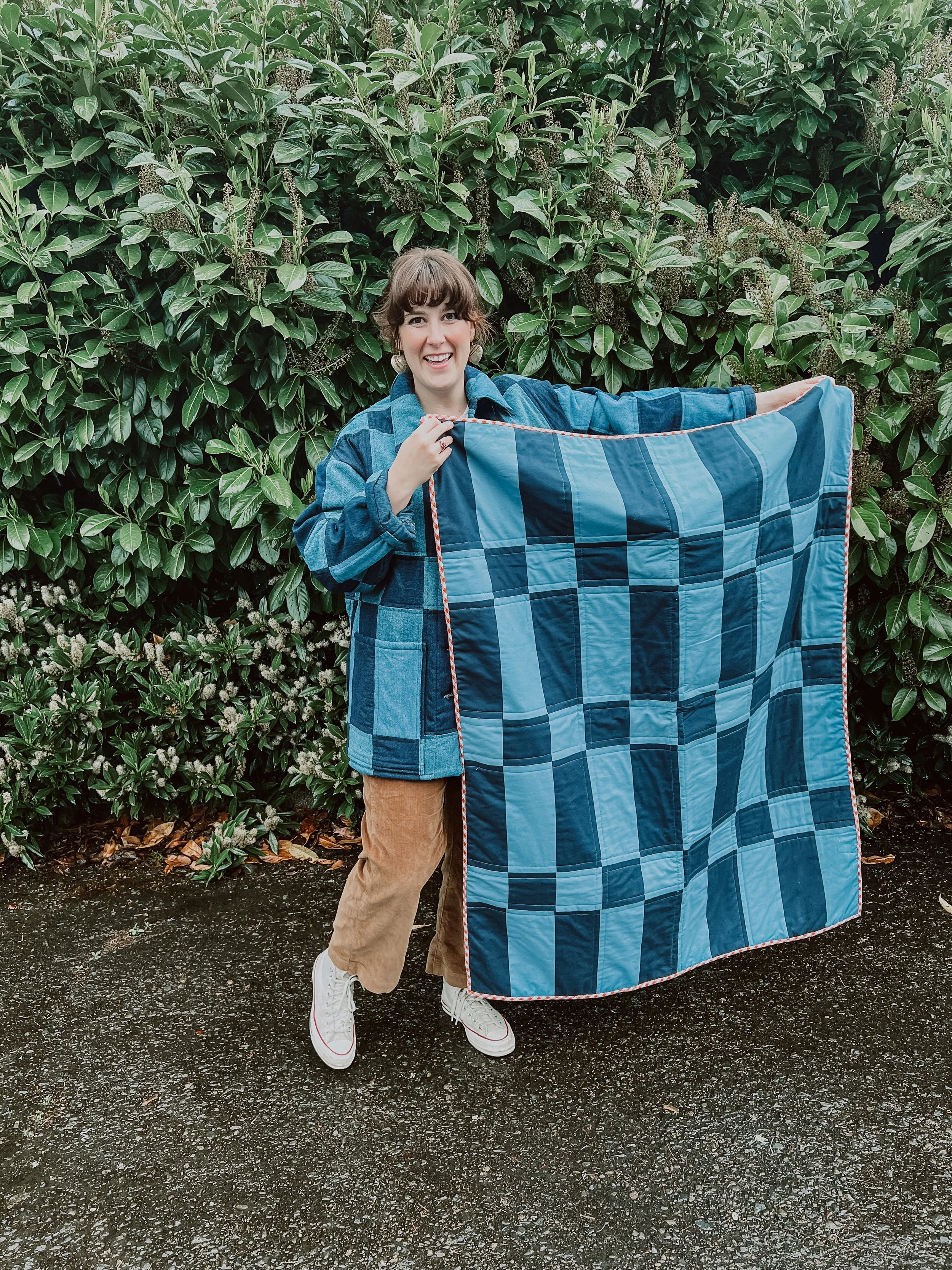 Person holding a crib quilt 
