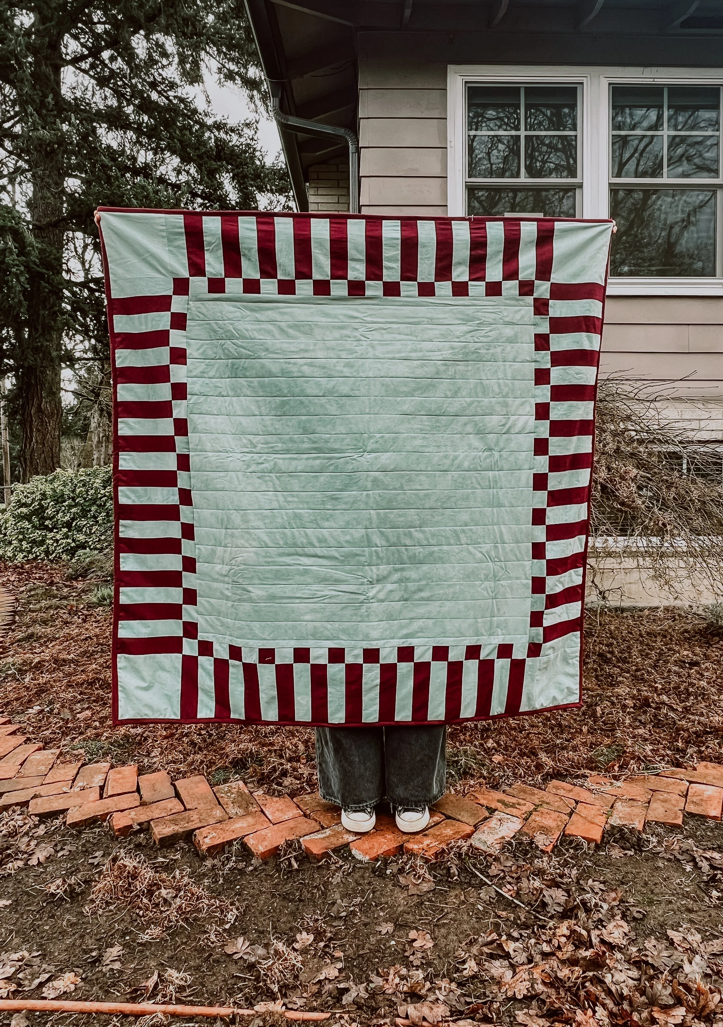 Sage and Maroon quilt in garden