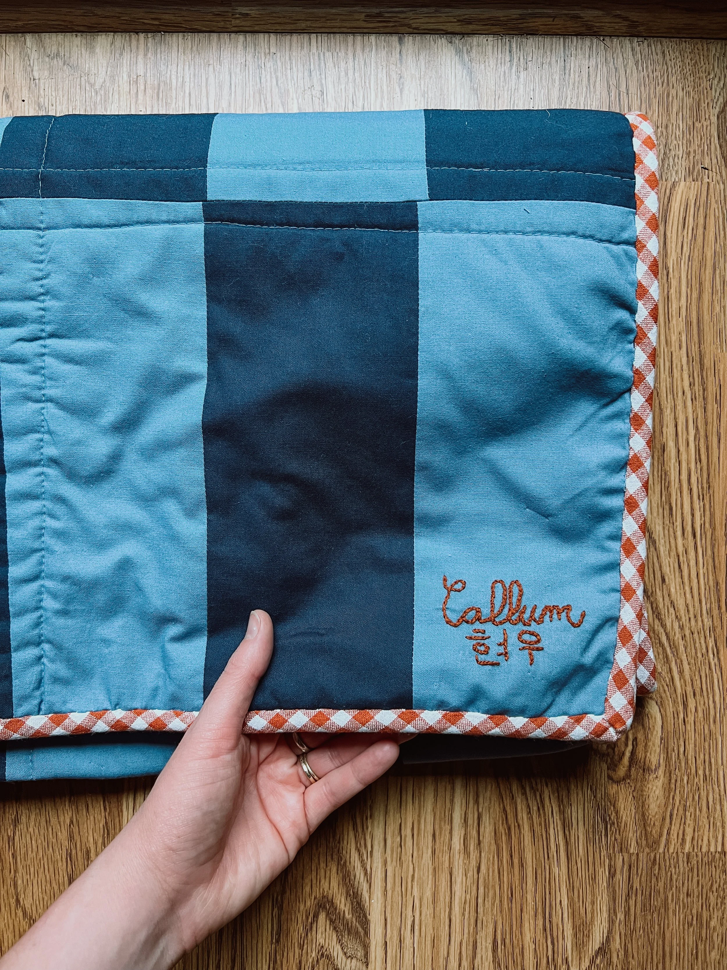 Folded crib quilt with embroidery