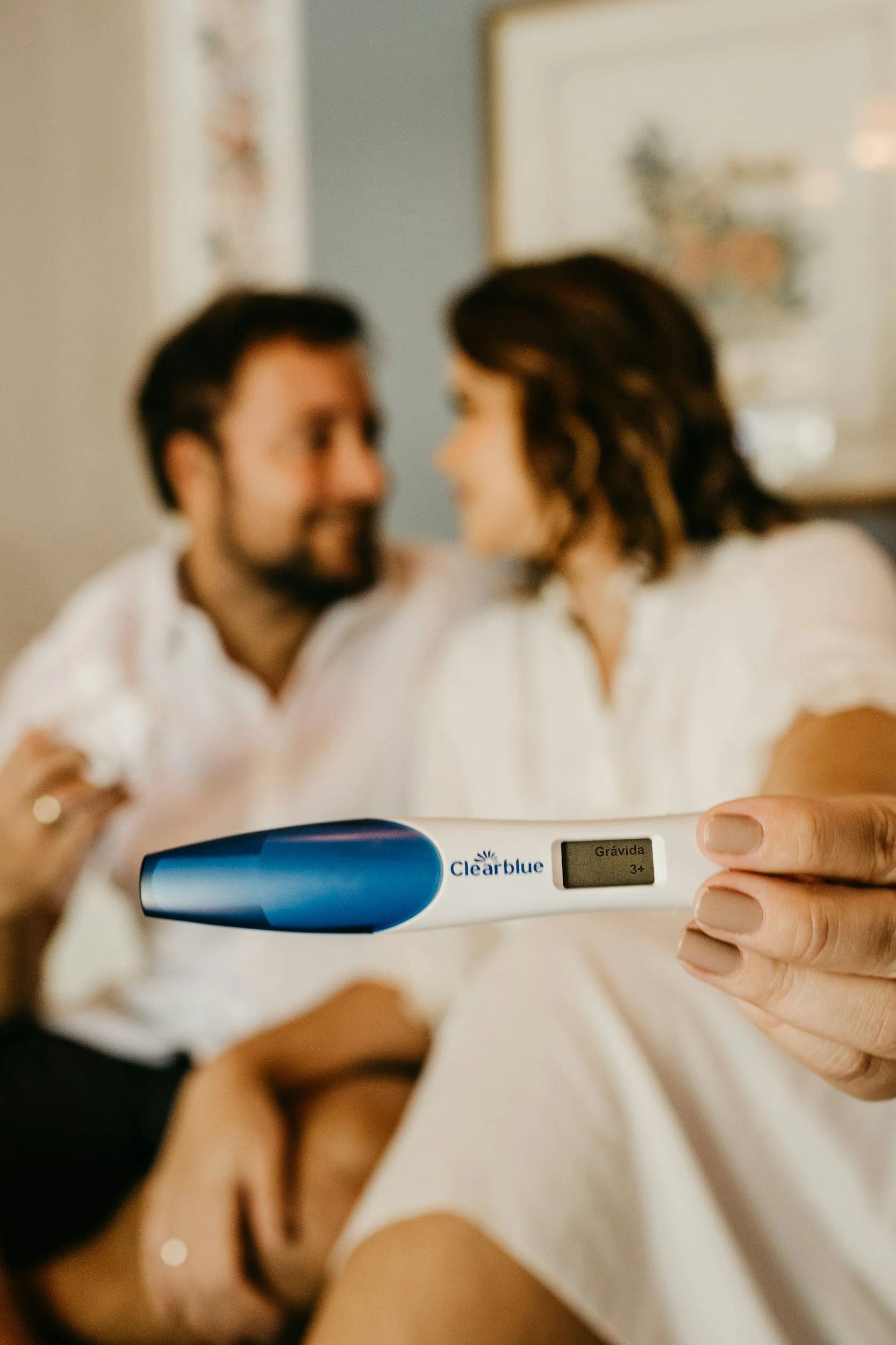 A woman holding a positive pregnancy test with