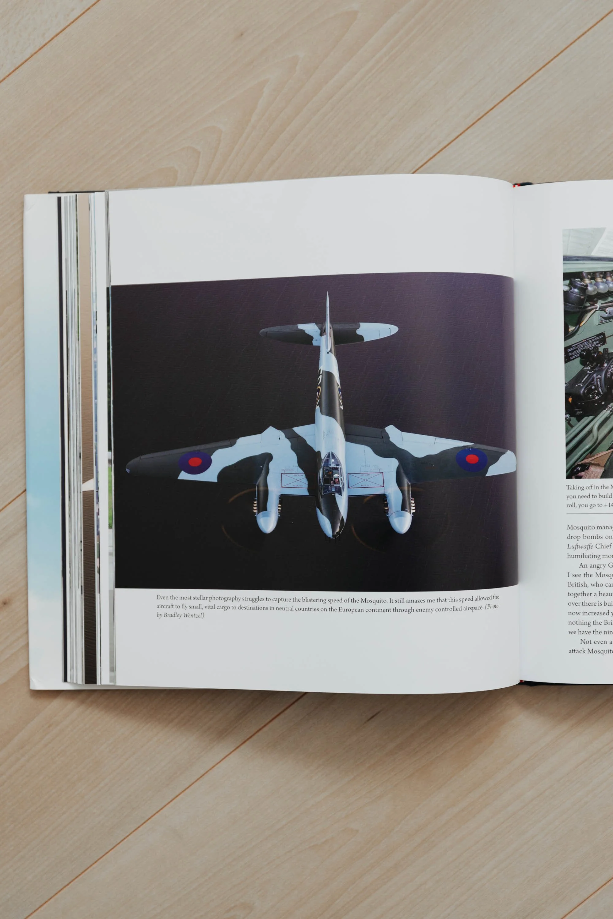 Open book displaying a photograph of an aircraft, possibly a de Havilland Mosquito, with RAF roundels visible, on a dark background.