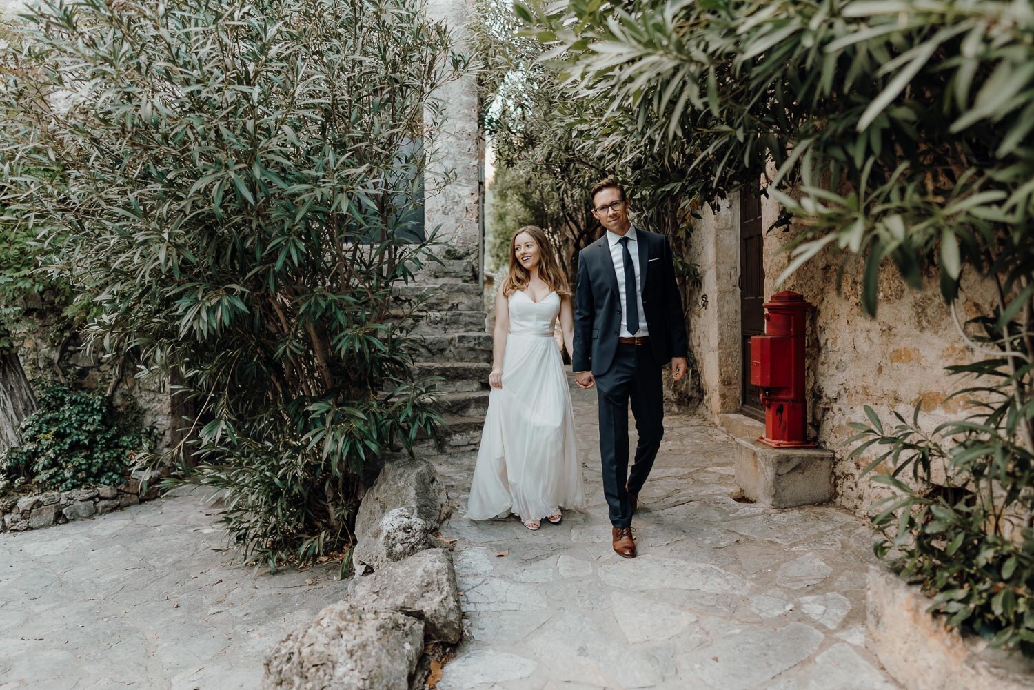 couple waling by trees Wedding in Saint Guilhem le Desert France