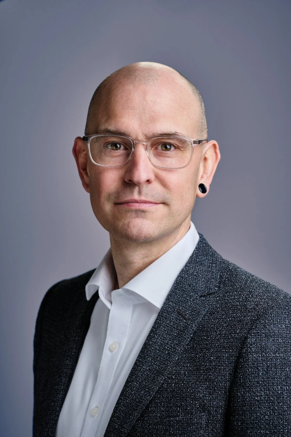 Professional headshot photo of a man in a shirt and jacket