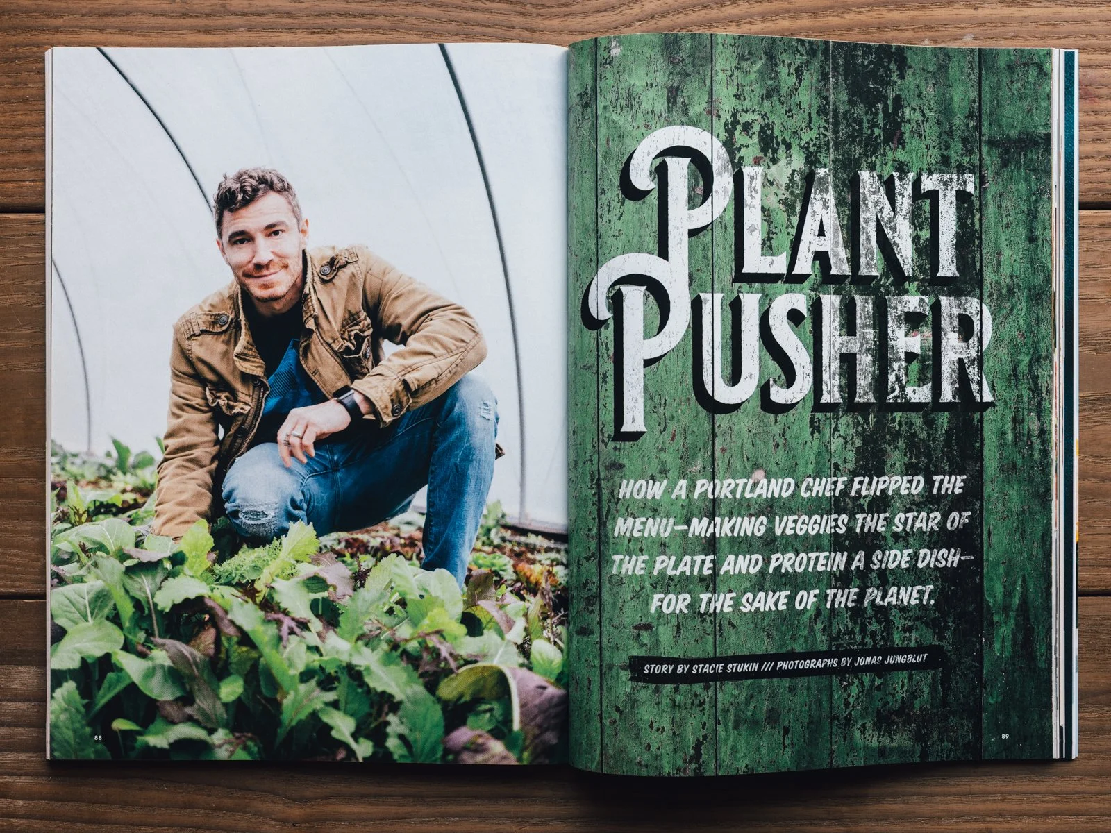 Magazine spread featuring a man crouching in a garden with leafy greens. The right page has a green, weathered wood background with bold white text reading 'Plant Pusher' and a subtitle about a Portland chef's veggie-inspired menu.