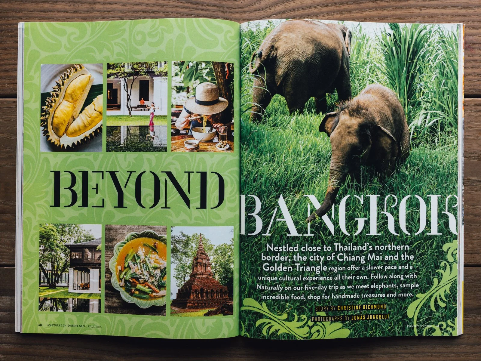 Open magazine with articles and photos about traveling beyond Bangkok, Thailand, featuring elephants in green jungle and various cultural and food images.