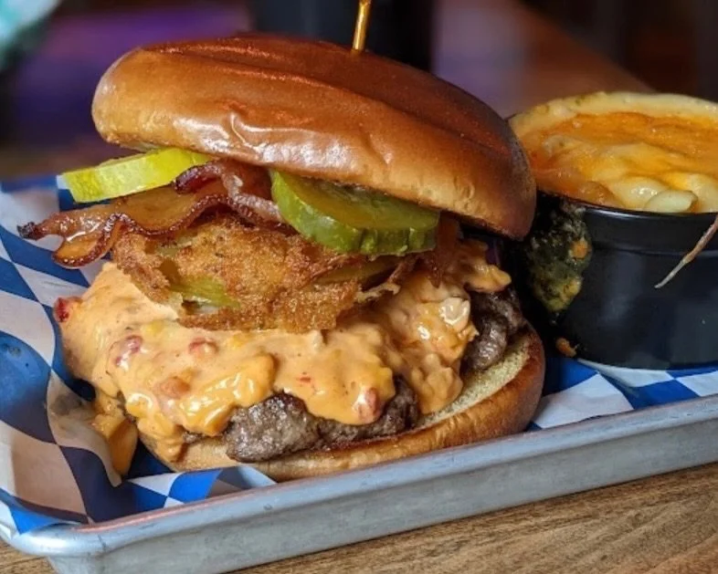 The Down Home Burger starts with a locally sourced @chopshopbutchery beef patty, then gets piled high with all the good stuff: candied bacon, pimento cheese, fried green tomatoes, and a drizzle of Daddy Mac&rsquo;s secret sauce.