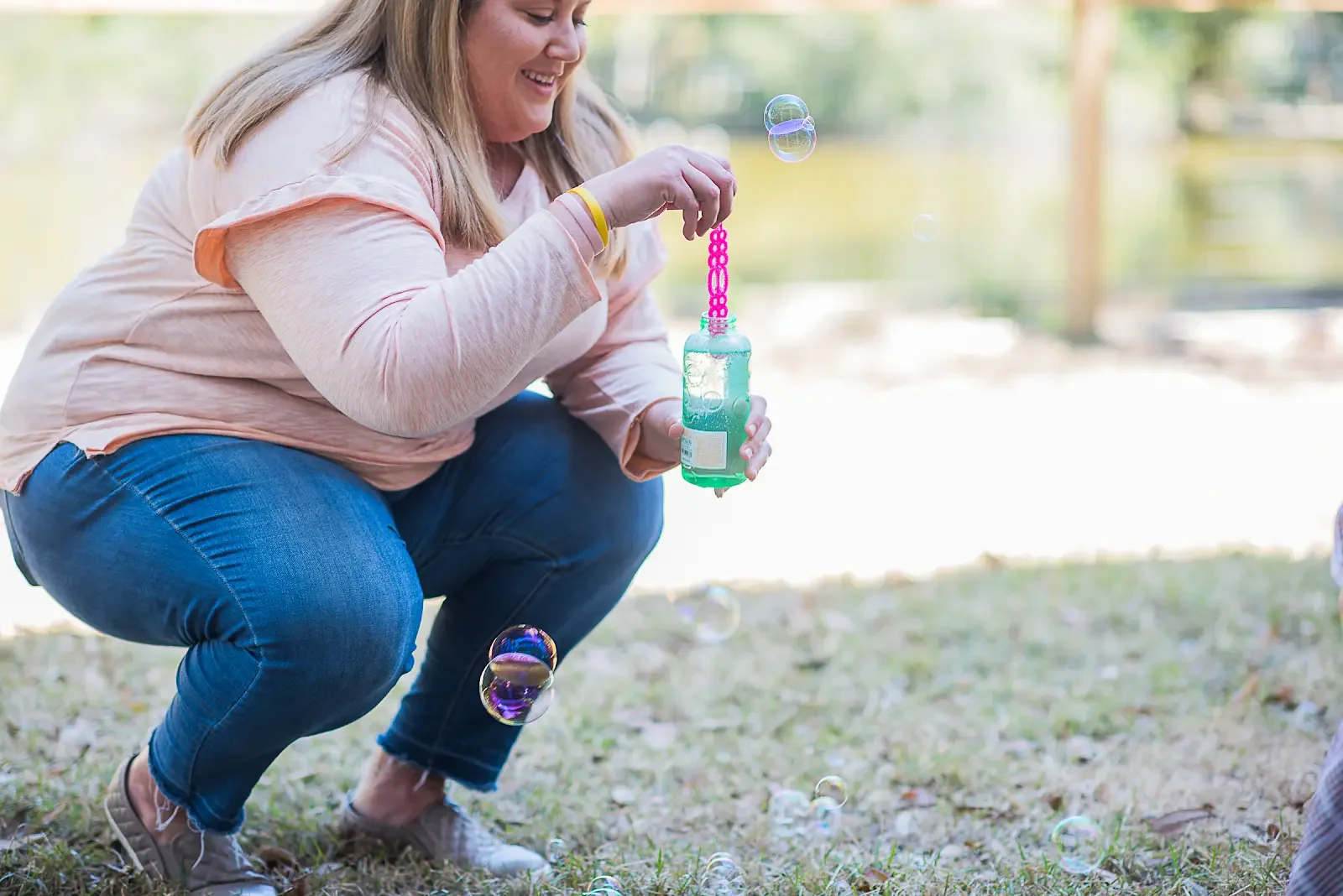 A Your Happy Nest Nanny Blowing Bubbles in the Park